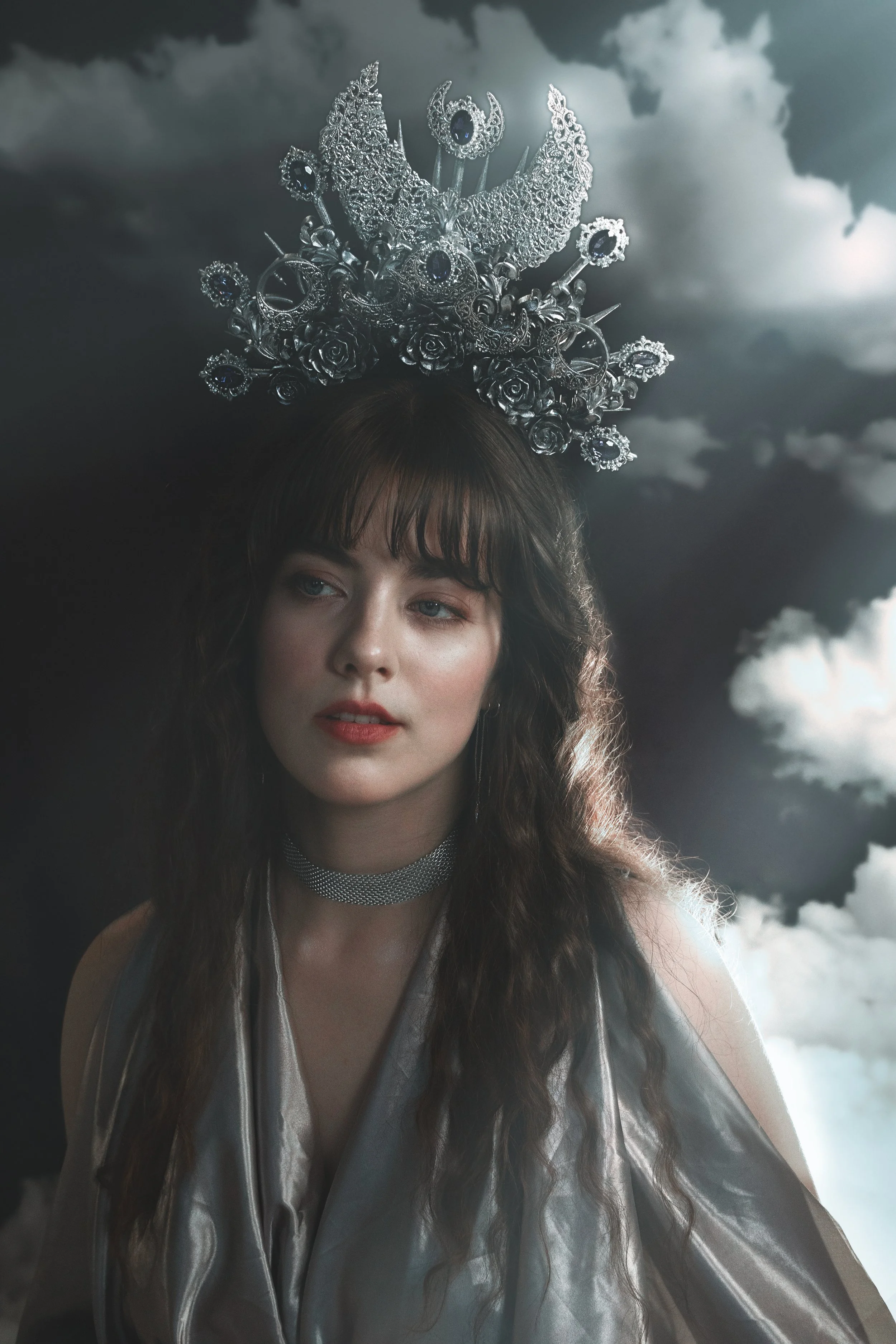 Fine art fantasy portrait of sun and moon goddesses with celestial crowns, clouds and dramatic light. Mythology inspired photography with golden and silver tones, painterly style and dreamy storytelling atmosphere.