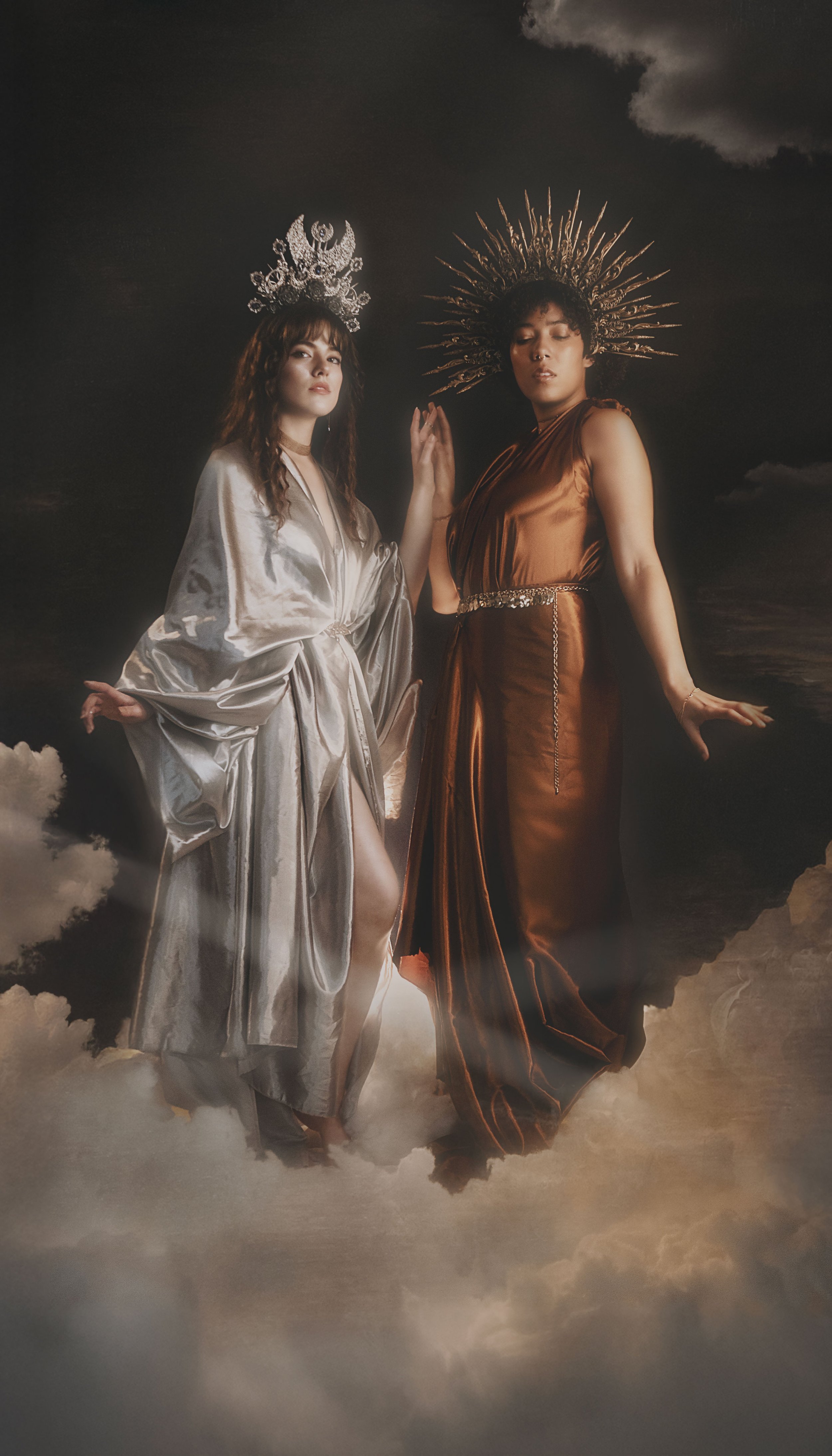 Fine art fantasy portrait of sun and moon goddesses with celestial crowns, clouds and dramatic light. Mythology inspired photography with golden and silver tones, painterly style and dreamy storytelling atmosphere.