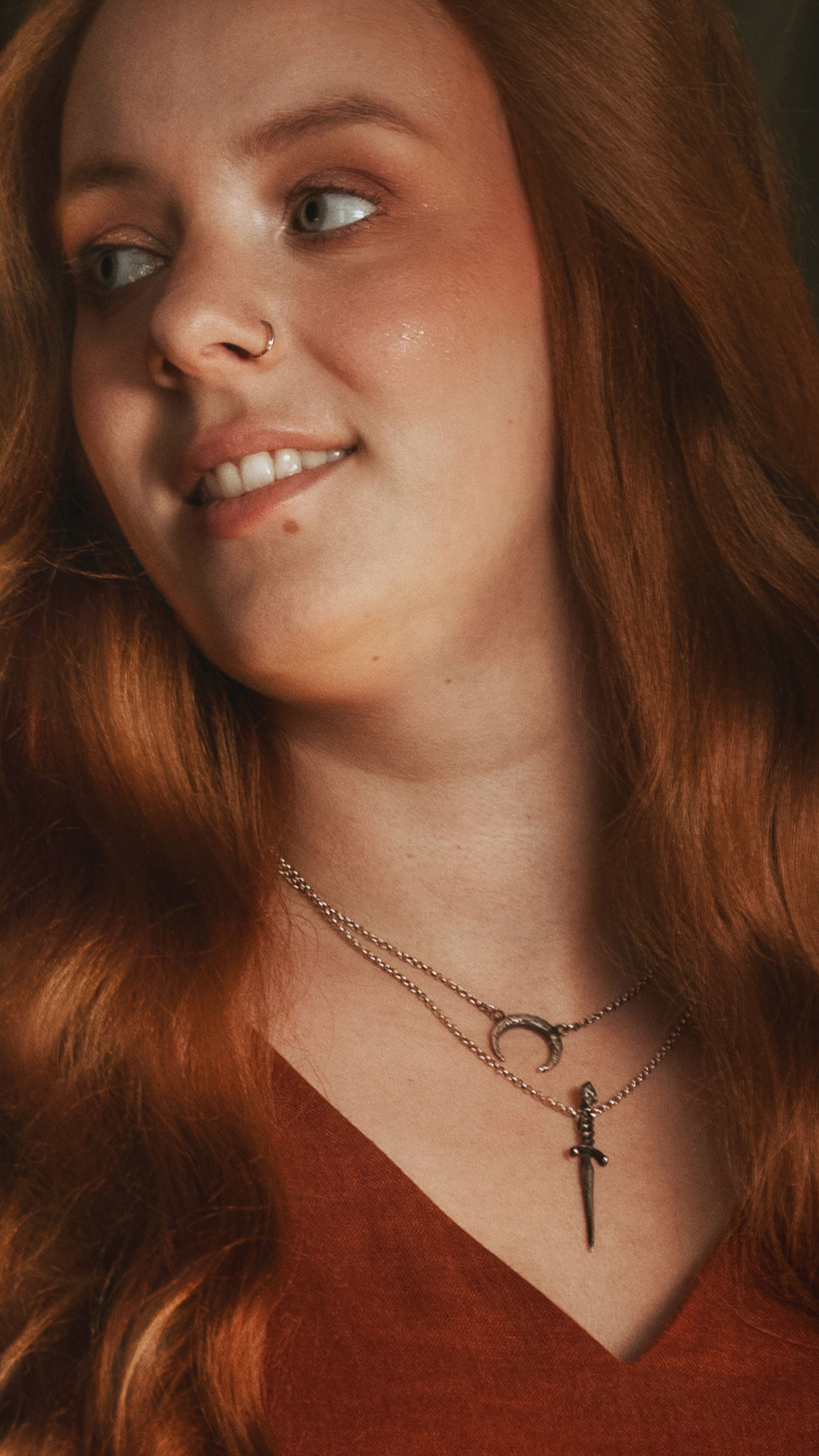 Dark romantic fine art portrait of a woman in deep red and violet tones with candlelight and vintage styling. Painterly fantasy photography inspired by baroque art and historical fashion, featuring rich fabrics and soft dramatic light.