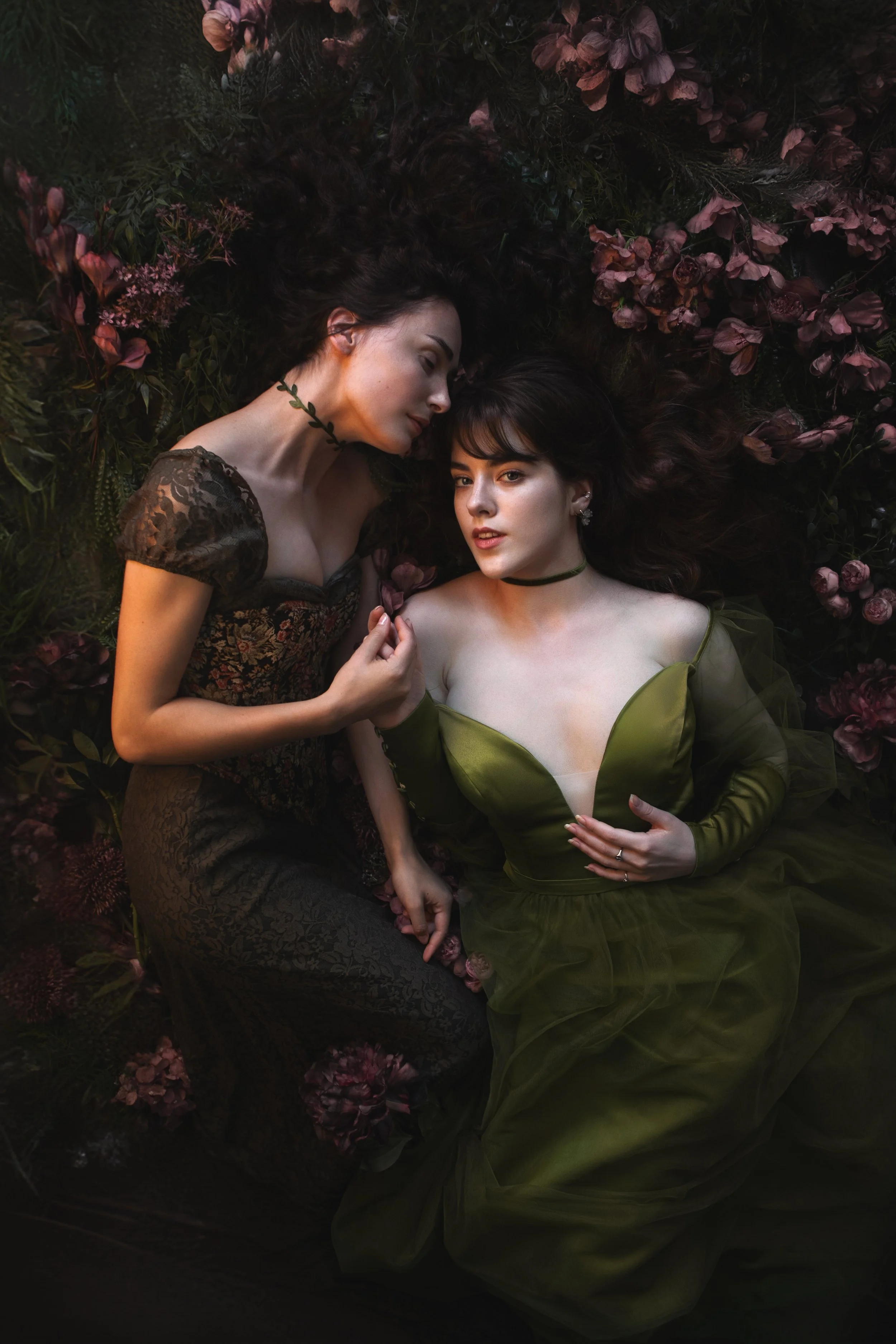 Dreamy fine art portraits of Mia and Talitha in a floral setting with rich green tones and romantic styling. Painterly fantasy photography inspired by classical art, nature and feminine storytelling. Intimate, emotional imagery with soft light, flowe