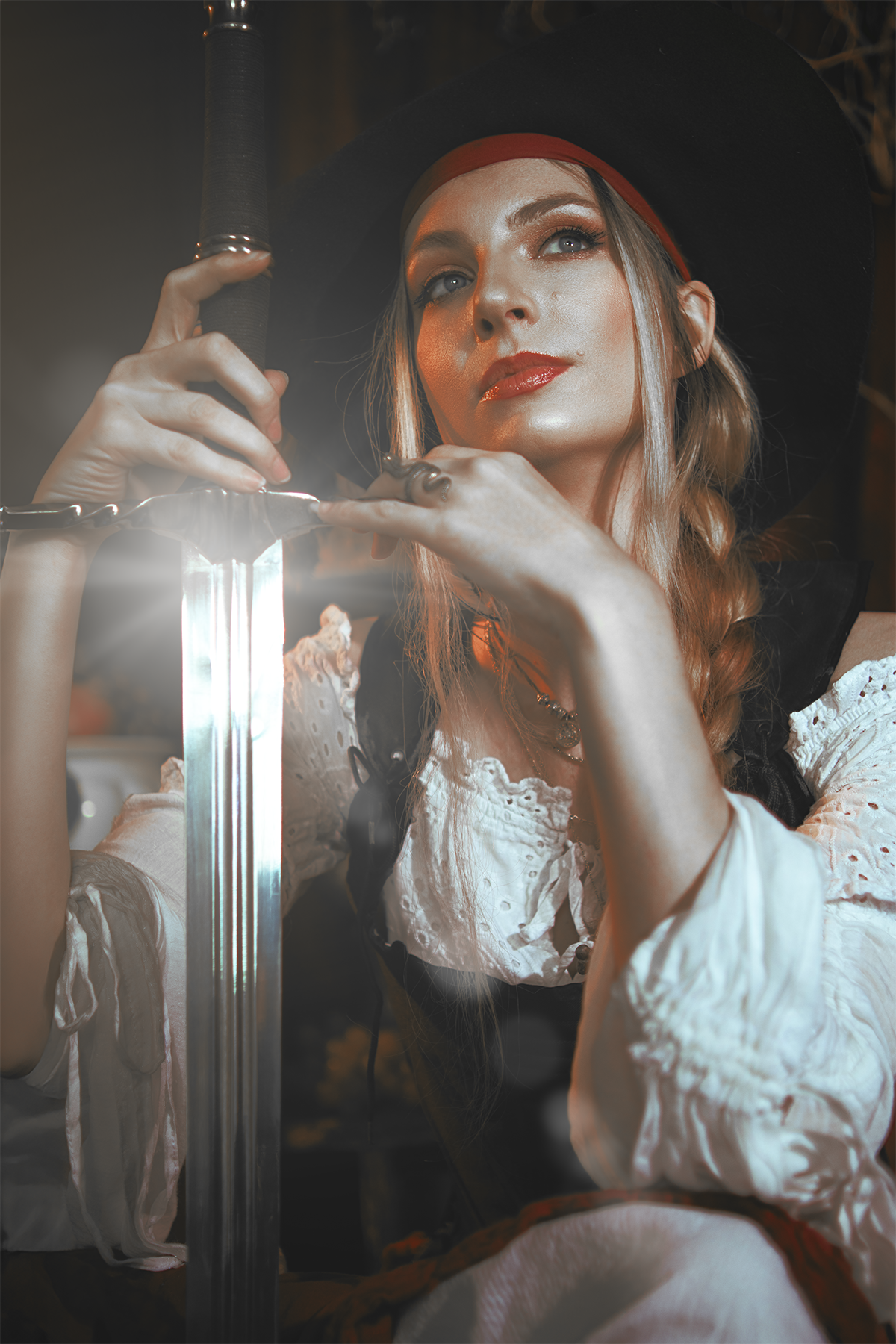 Pirate inspired cosplay portrait with sword and historical styling. Fine art fantasy photography influenced by seafaring adventures and vintage aesthetics, featuring warm light and a cinematic storytelling atmosphere.