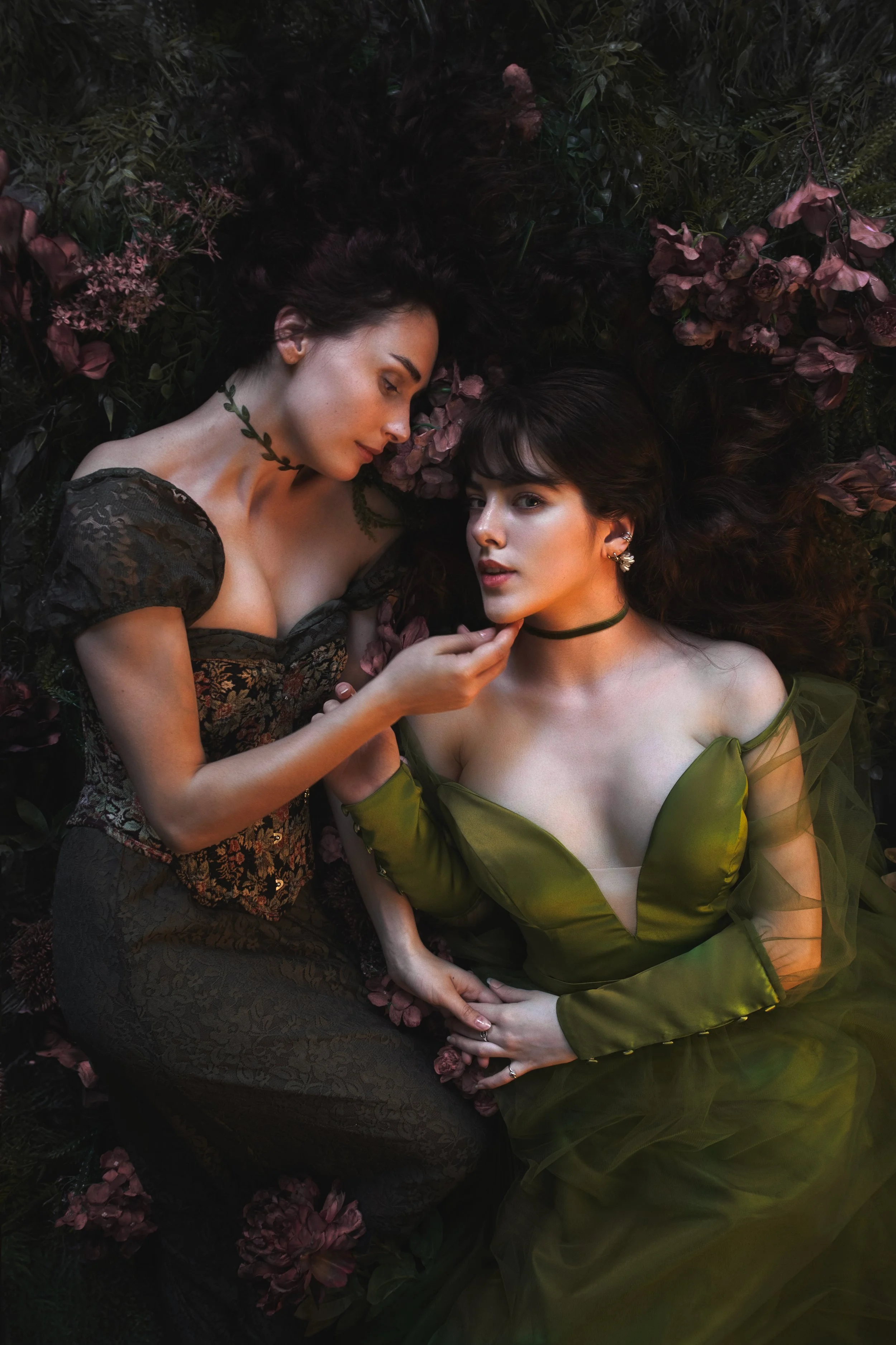 Dreamy fine art portraits of Mia and Talitha in a floral setting with rich green tones and romantic styling. Painterly fantasy photography inspired by classical art, nature and feminine storytelling. Intimate, emotional imagery with soft light, flowe
