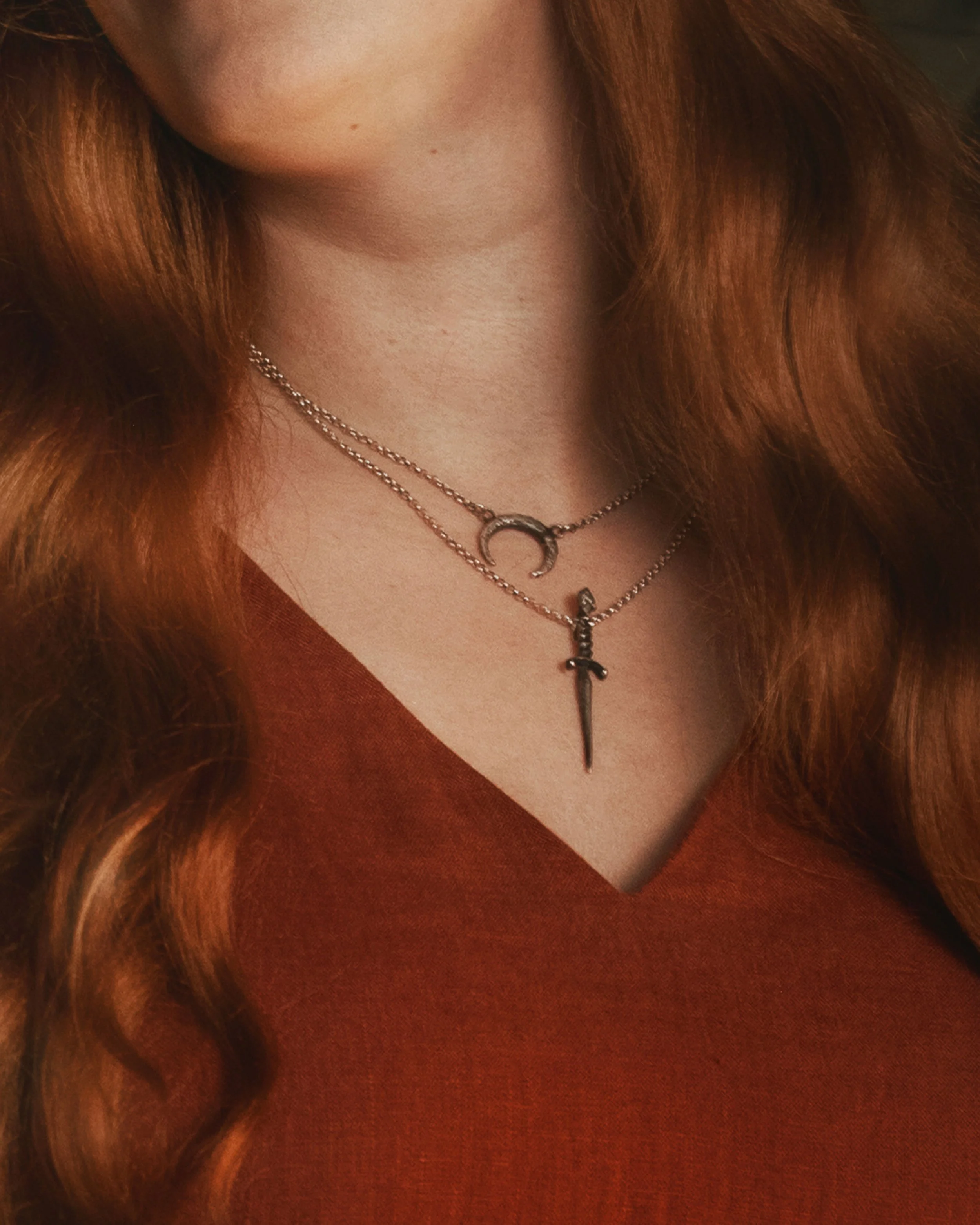 Dark romantic fine art portrait of a woman in deep red and violet tones with candlelight and vintage styling. Painterly fantasy photography inspired by baroque art and historical fashion, featuring rich fabrics and soft dramatic light.