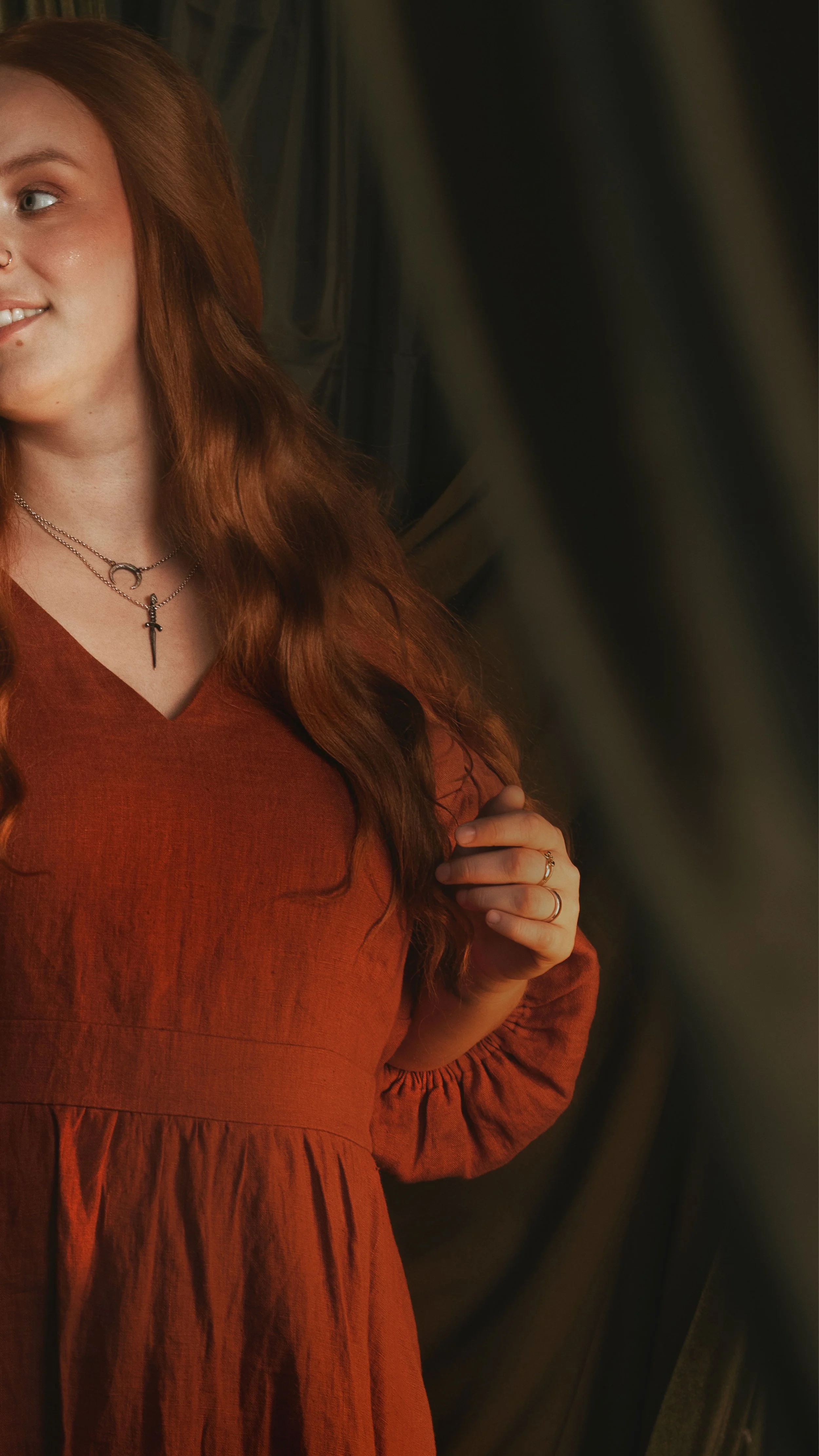 Dark romantic fine art portrait of a woman in deep red and violet tones with candlelight and vintage styling. Painterly fantasy photography inspired by baroque art and historical fashion, featuring rich fabrics and soft dramatic light.