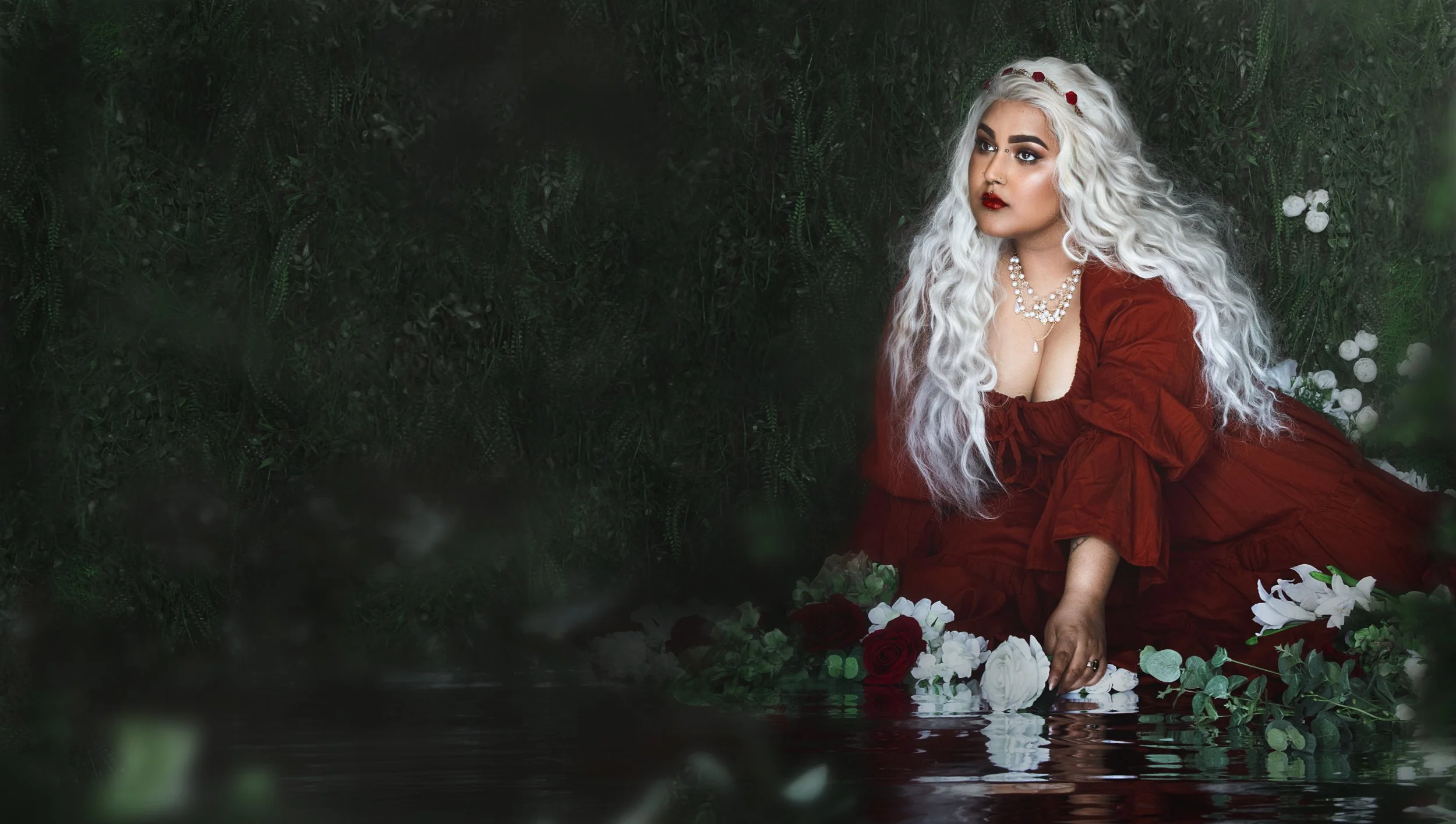 Dreamy fine art portrait of Neesha with rich green and crimson tones, inspired by folklore and classical paintings. Romantic, painterly fantasy photography featuring flowers, water and soft candlelight. Emotional storytelling imagery in a fine art st