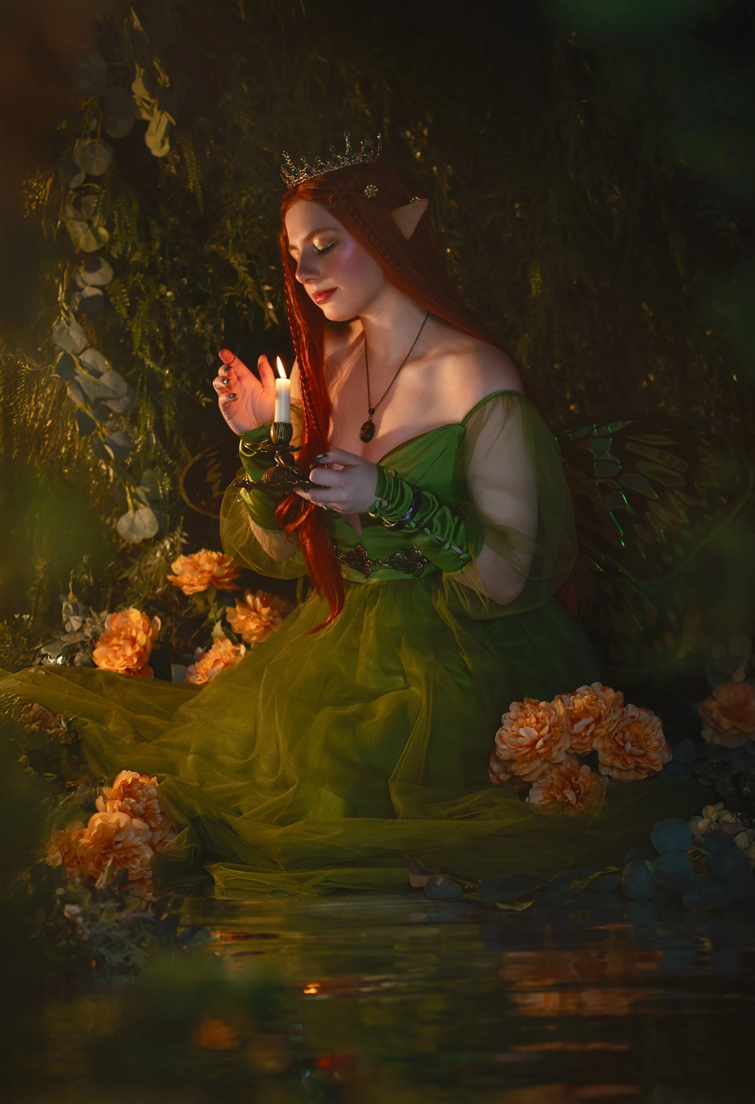 Dreamy fine art portrait of Natasha as a forest nymph surrounded by water, flowers and candlelight. Painterly fantasy photography inspired by folklore and nature mythology, featuring rich green tones and soft golden light.