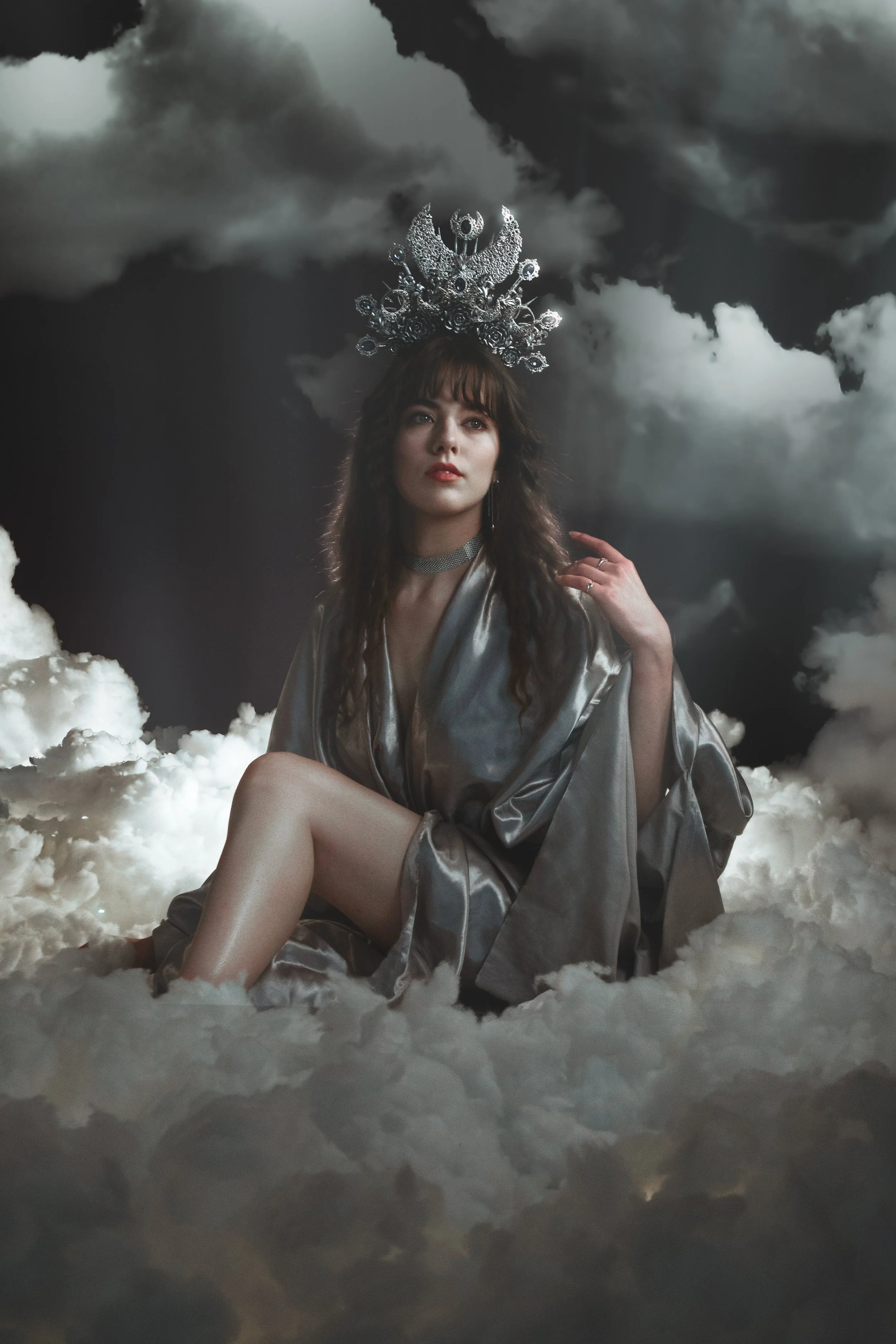 Fine art fantasy portrait of sun and moon goddesses with celestial crowns, clouds and dramatic light. Mythology inspired photography with golden and silver tones, painterly style and dreamy storytelling atmosphere.