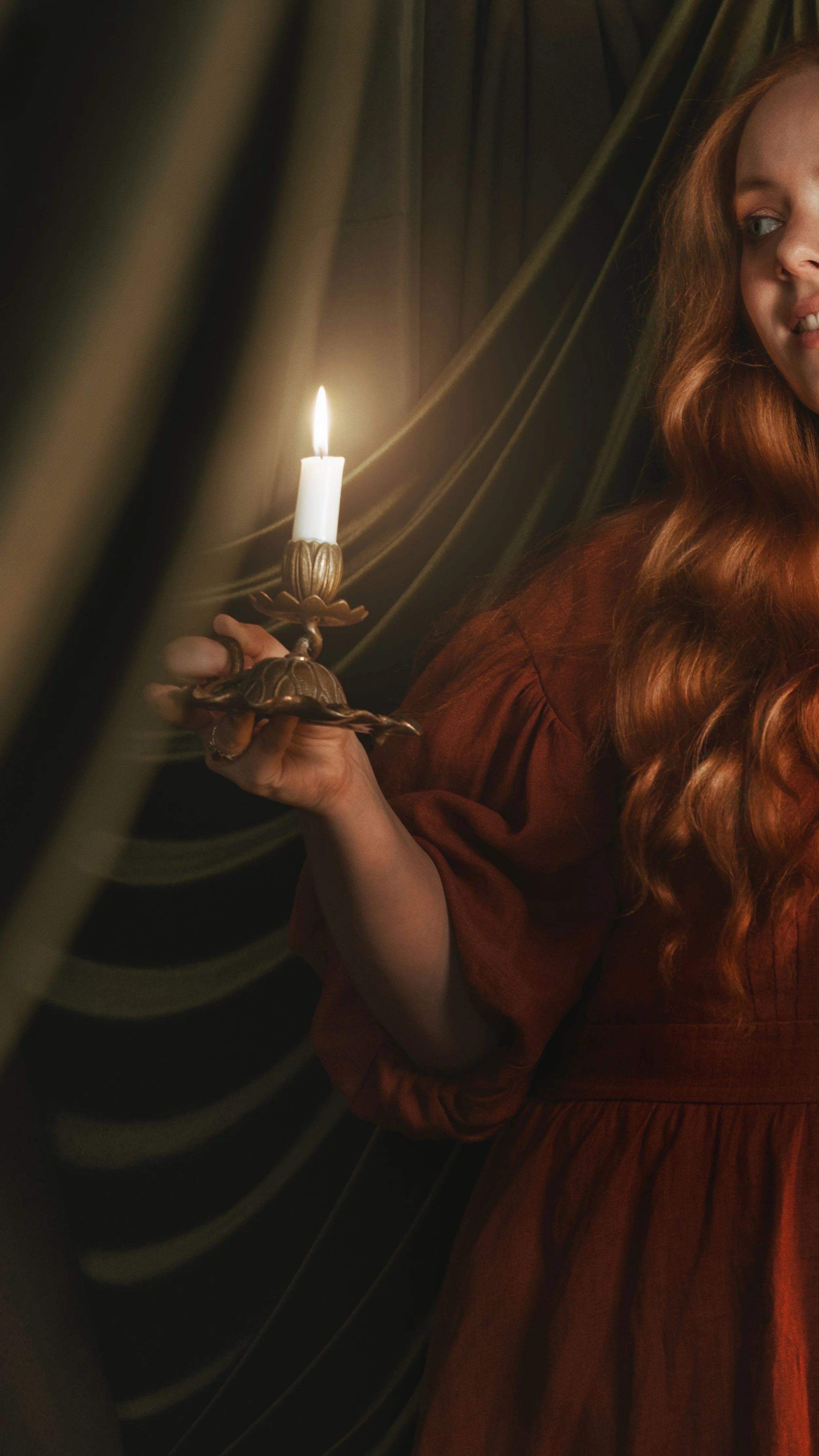 Dark romantic fine art portrait of a woman in deep red and violet tones with candlelight and vintage styling. Painterly fantasy photography inspired by baroque art and historical fashion, featuring rich fabrics and soft dramatic light.