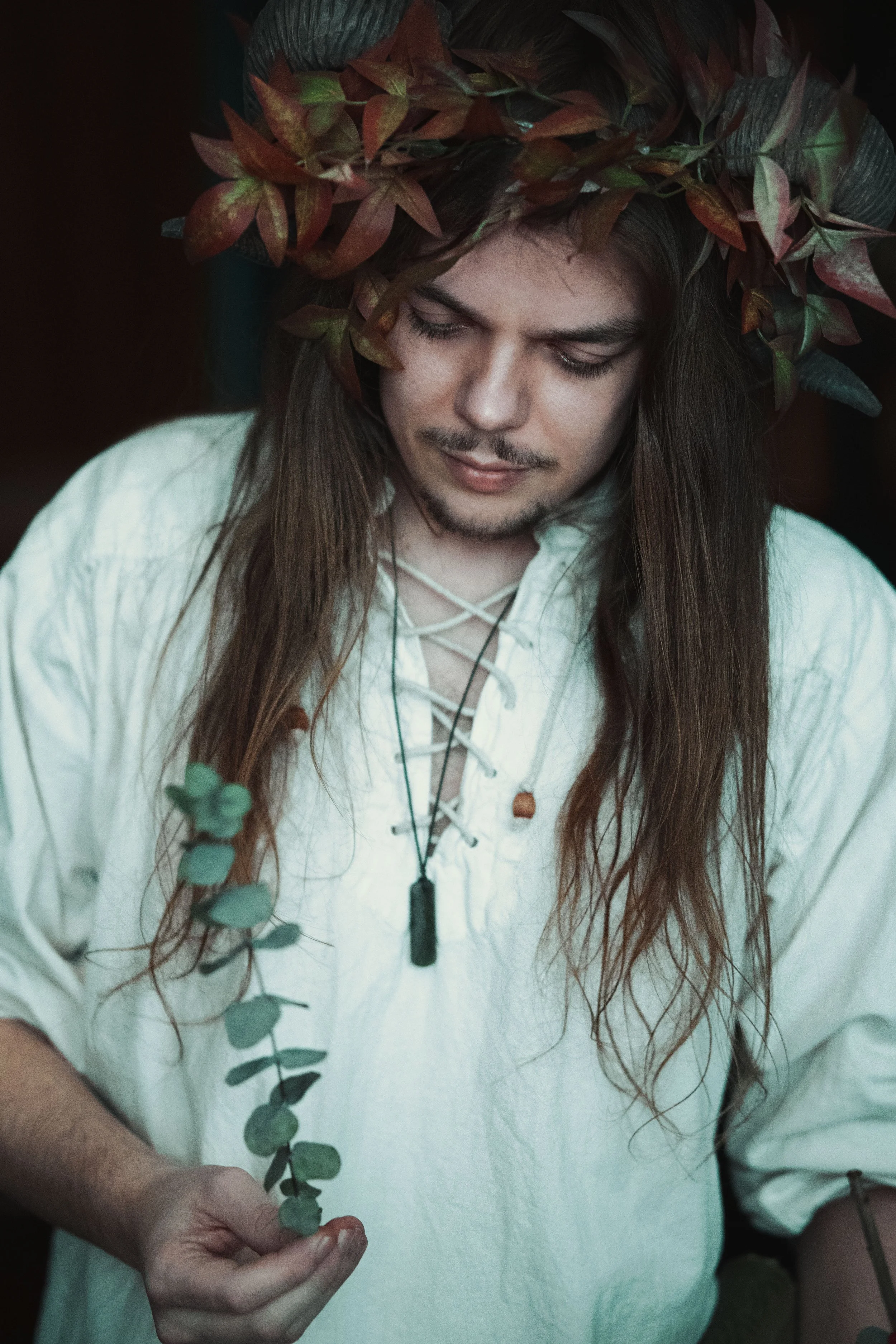 Dreamy fine art portrait of Thijs as a forest druid surrounded by leaves and candlelight. Painterly fantasy photography inspired by folklore and nature, with moody light and storytelling atmosphere. Romantic woodland imagery in a fine art studio sett