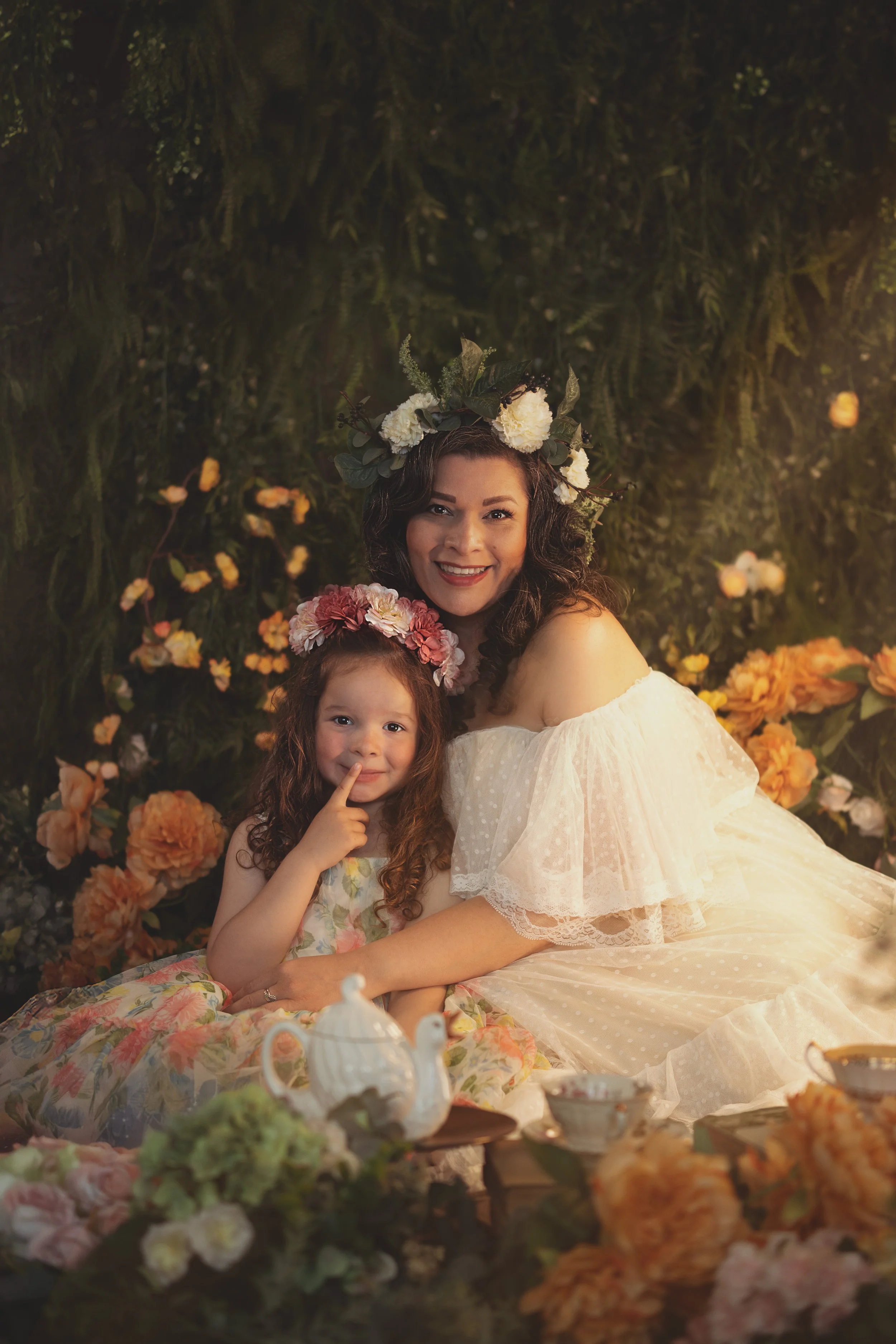 Dreamy mommy and me fine art portrait of a mother and child surrounded by flowers and soft golden light. Painterly photography inspired by fairytales and nature, capturing tenderness, connection and a warm storytelling atmosphere.