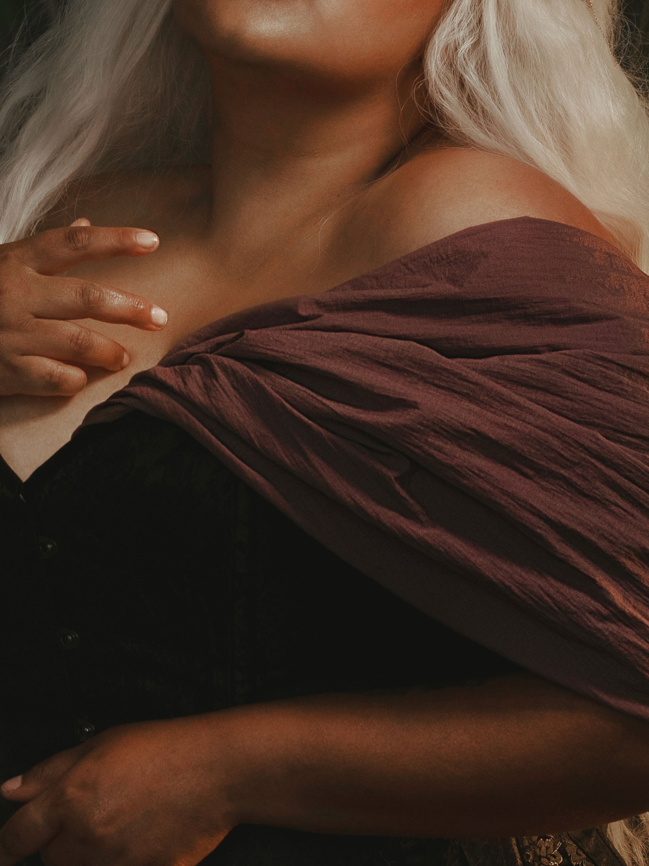 Dark romantic fine art portrait of a woman in deep red and violet tones with candlelight and vintage styling. Painterly fantasy photography inspired by baroque art and historical fashion, featuring rich fabrics and soft dramatic light.