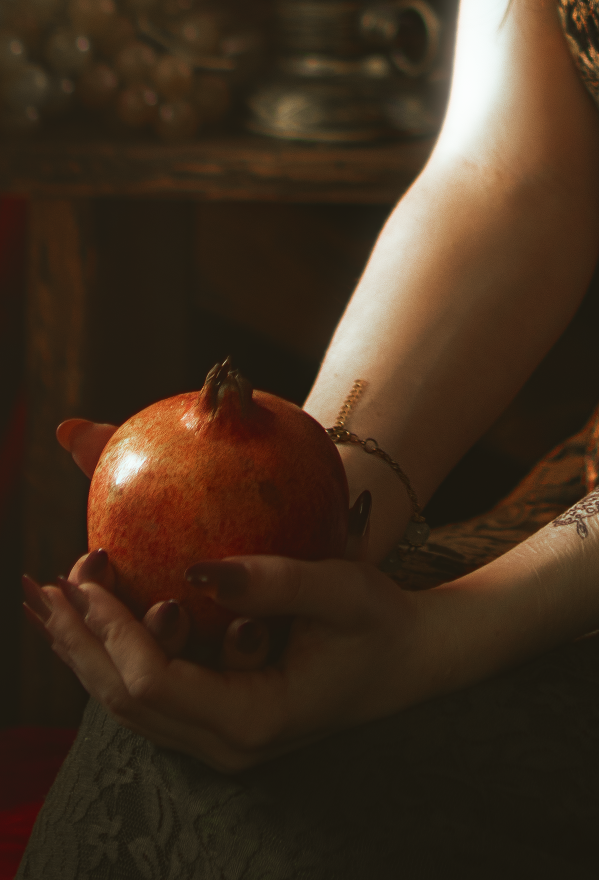 Persephone inspired dark goddess cosplay portrait with pomegranate, red velvet and candlelight. Fine art fantasy photography based on Greek mythology, featuring rich colors and a moody, storytelling atmosphere.