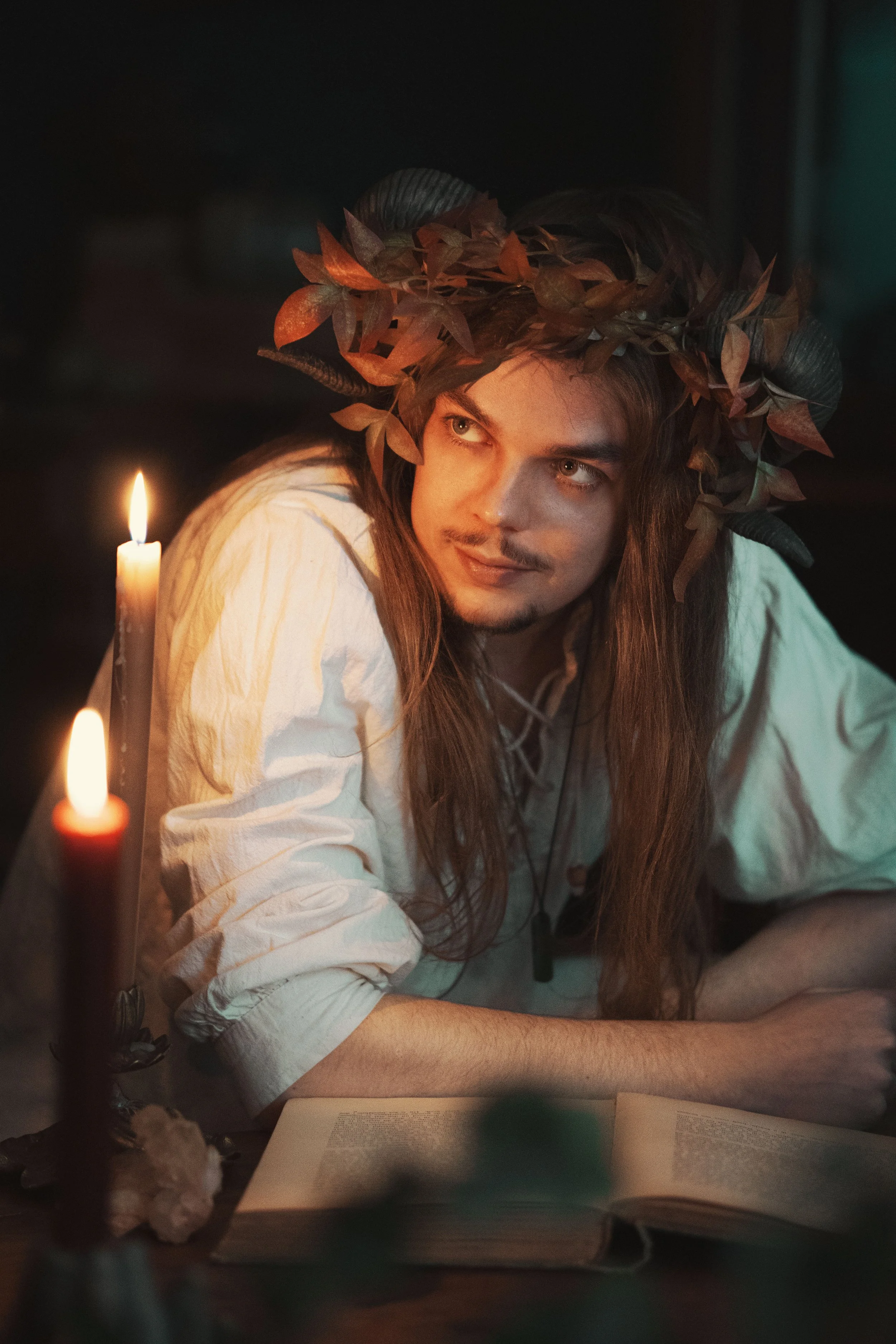 Dreamy fine art portrait of Thijs as a forest druid surrounded by leaves and candlelight. Painterly fantasy photography inspired by folklore and nature, with moody light and storytelling atmosphere. Romantic woodland imagery in a fine art studio sett