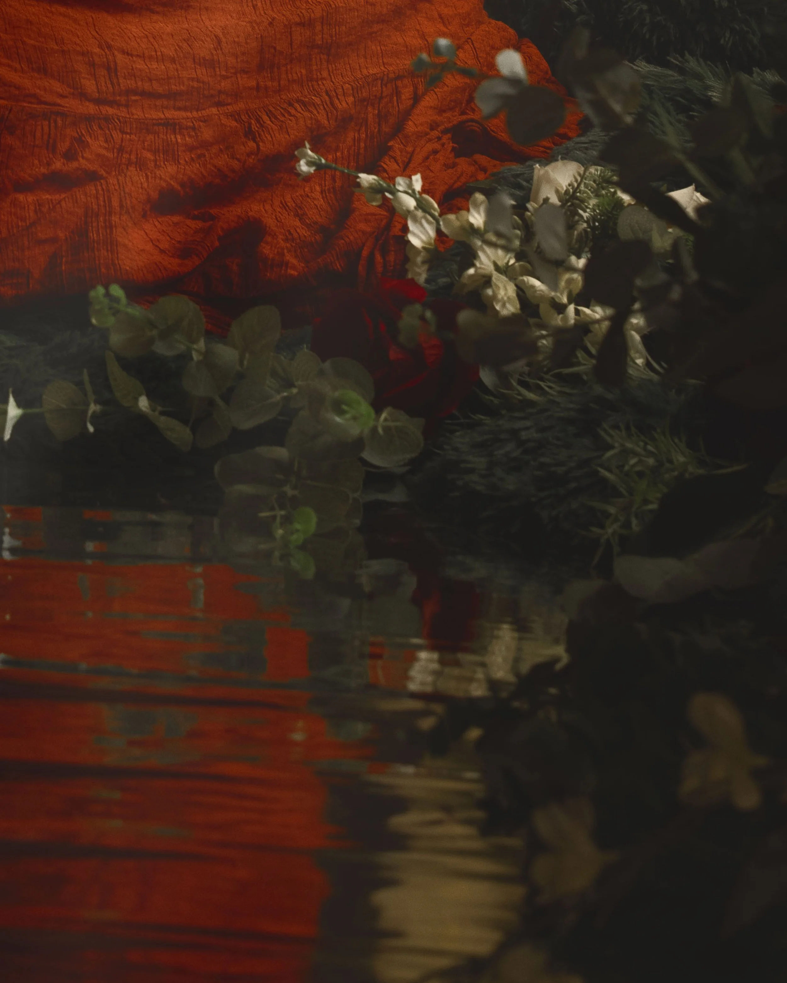 Dreamy fine art portrait of a woman in water surrounded by flowers and soft reflections. Painterly fantasy photography inspired by folklore, mythology and classical paintings. Romantic, ethereal imagery with storytelling atmosphere and natural elemen