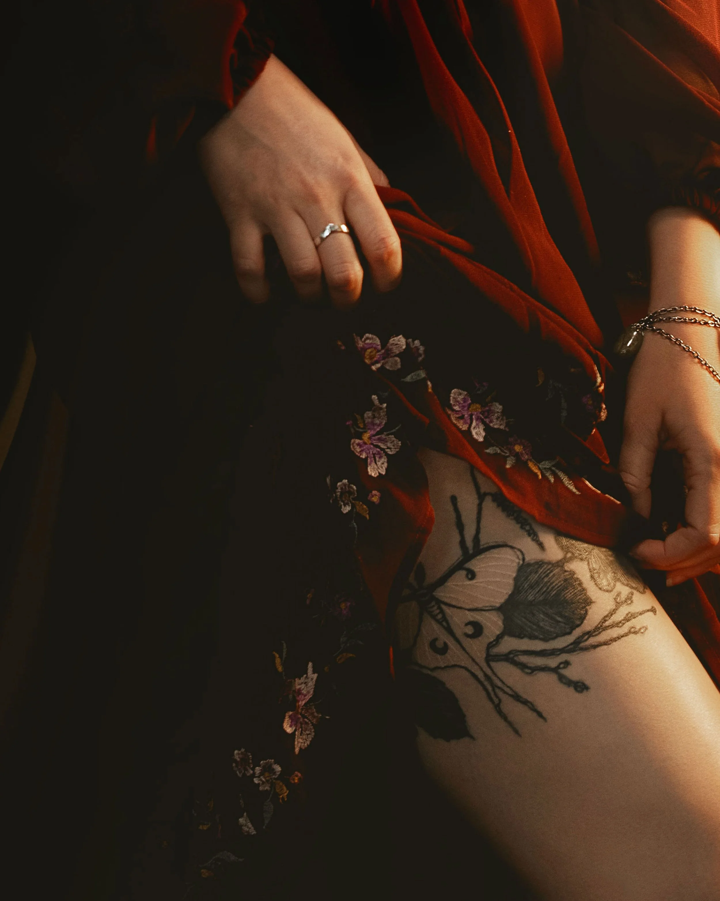 Dark romantic fine art portrait of a woman in deep red and violet tones with candlelight and vintage styling. Painterly fantasy photography inspired by baroque art and historical fashion, featuring rich fabrics and soft dramatic light.