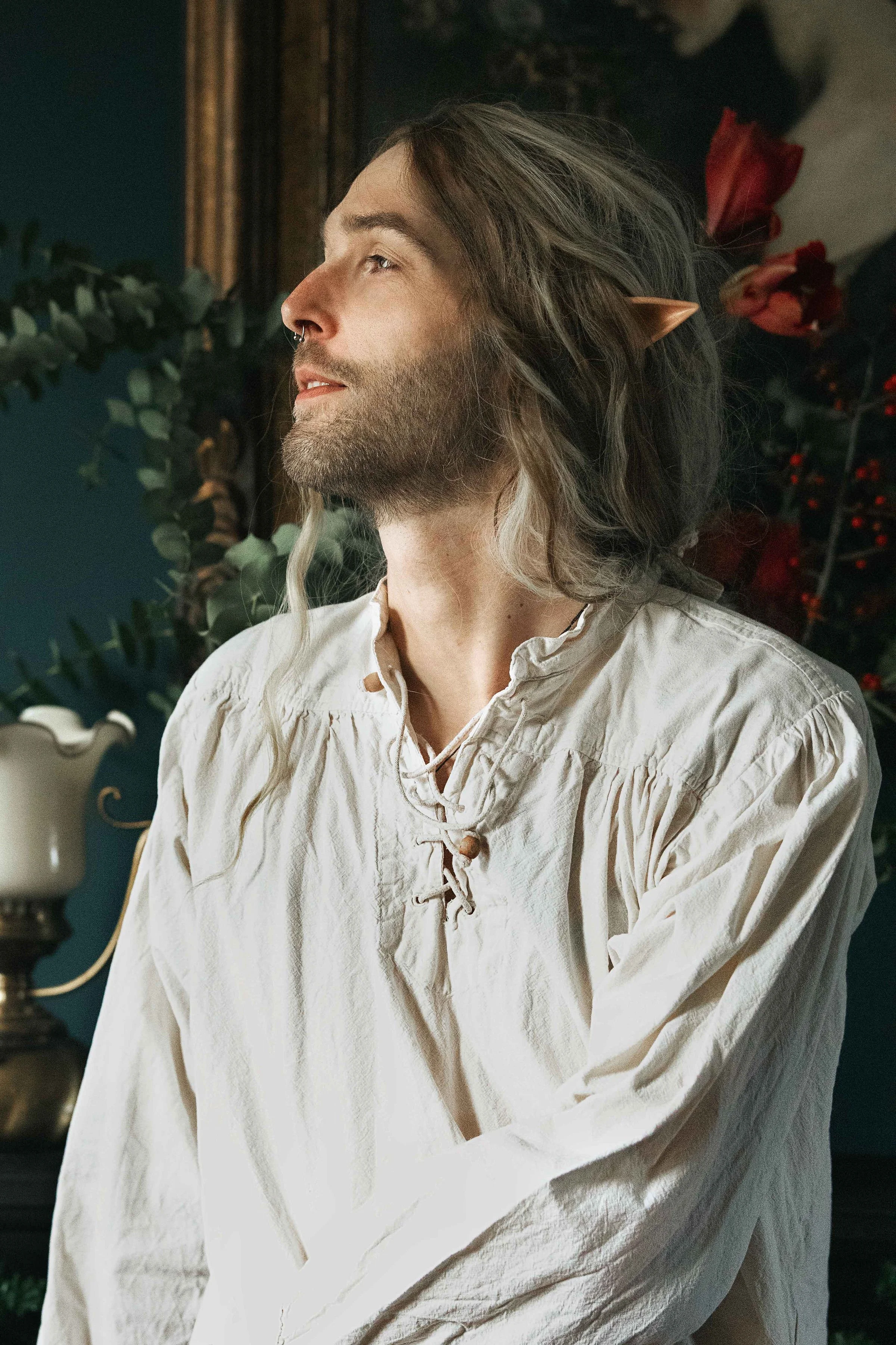 Dreamy fine art portrait of Rico as a scholar reading by candlelight. Painterly fantasy photography inspired by folklore and classical paintings, featuring books, glass bottles and warm light. Moody, romantic storytelling imagery in a fine art studio
