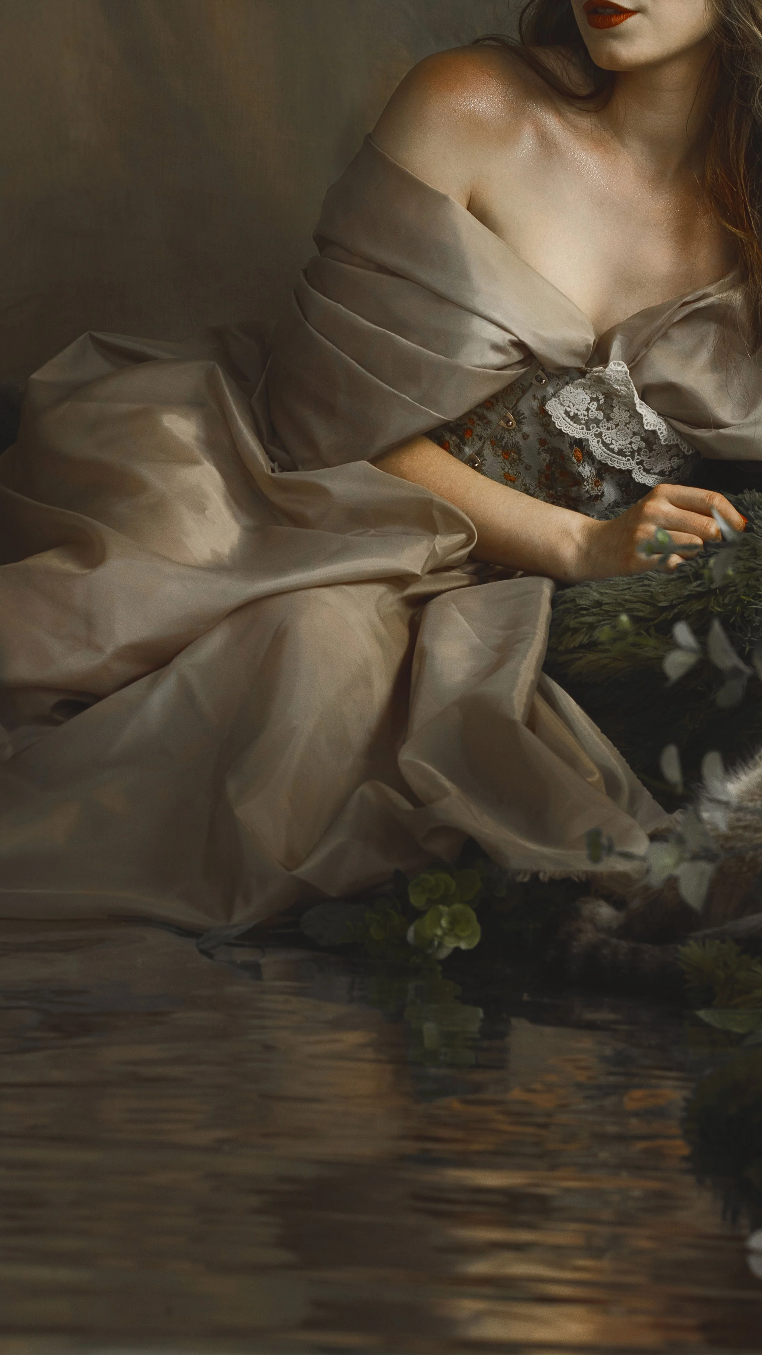 Dreamy fine art portrait of a woman in water surrounded by flowers and soft reflections. Painterly fantasy photography inspired by folklore, mythology and classical paintings. Romantic, ethereal imagery with storytelling atmosphere and natural elemen