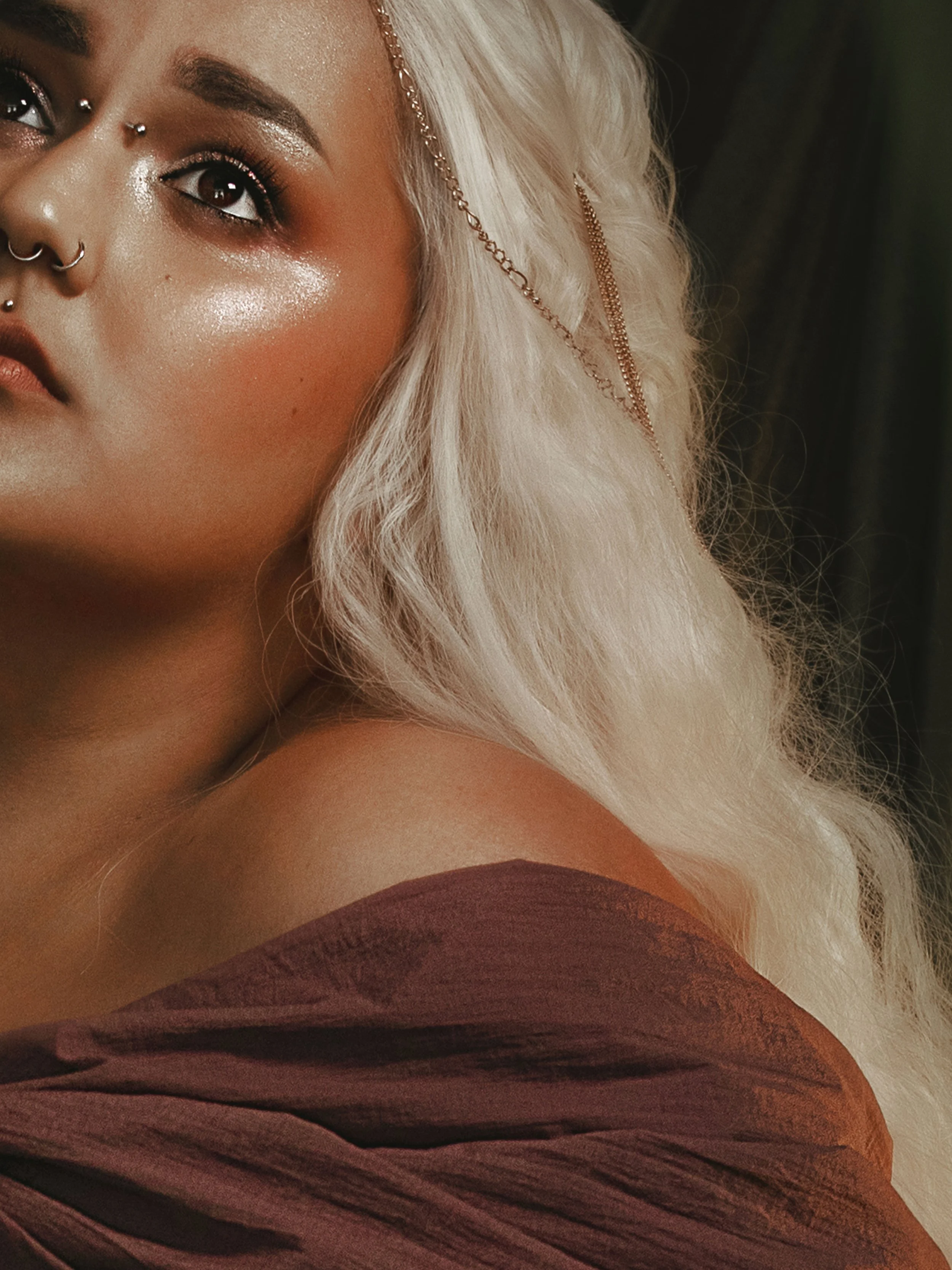 Dark romantic fine art portrait of a woman in deep red and violet tones with candlelight and vintage styling. Painterly fantasy photography inspired by baroque art and historical fashion, featuring rich fabrics and soft dramatic light.