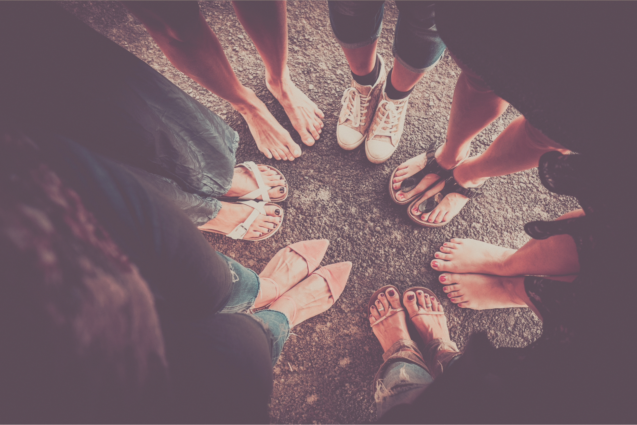 Grupo de personas de diferentes estilos de calzado y ropa formando un círculo visto desde arriba.