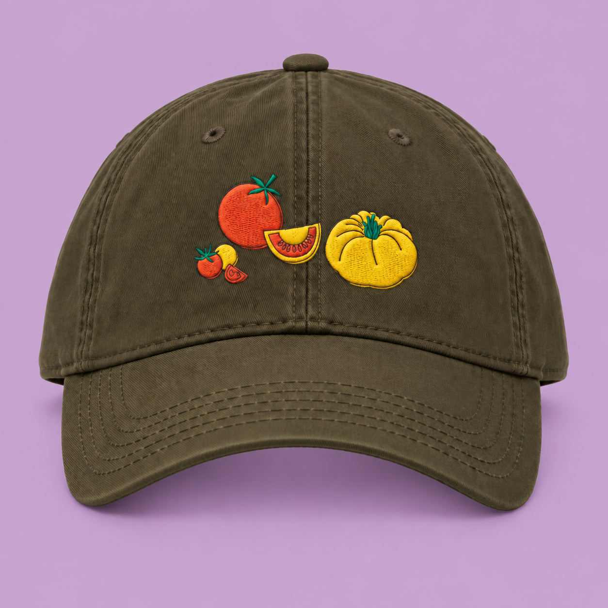 Olive green organic cotton cap with quirky tomato embroidery on a lilac background.