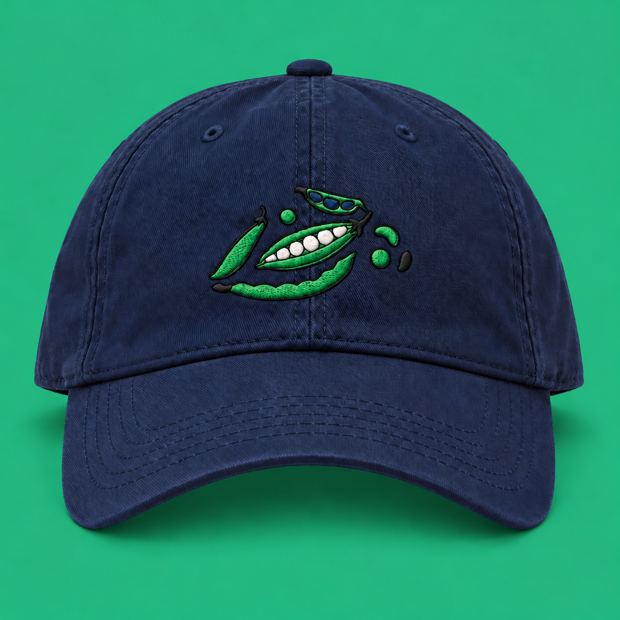 Navy organic cotton cap with embroidered peas and beans on a green background.