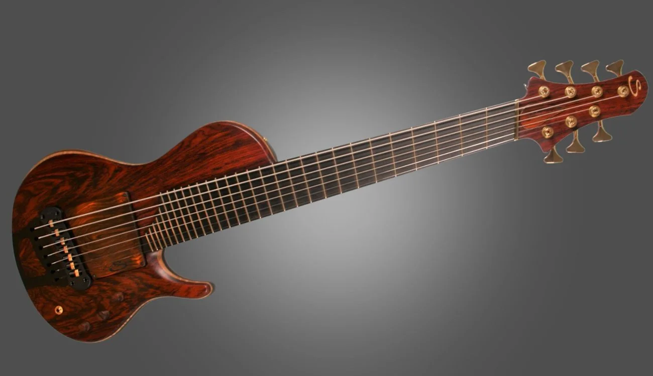 A brown electric guitar with gold tuning pegs and a wooden finish against a gray background.