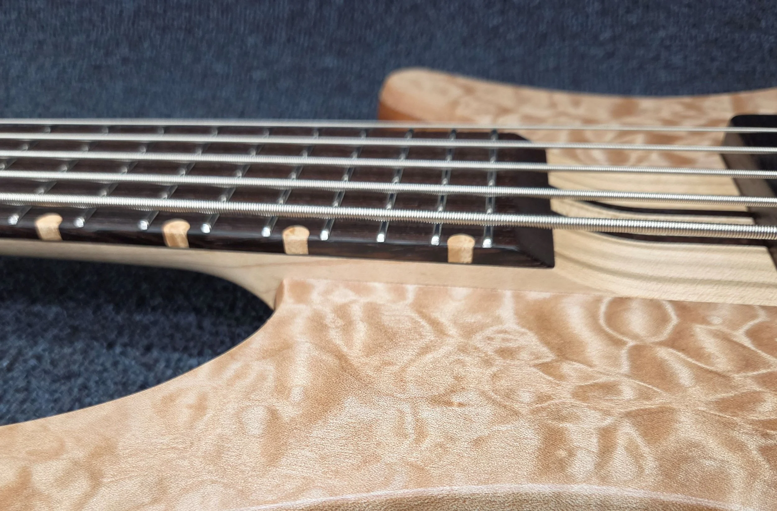 The wenge fingerboard features Birdseye Maple edge dots and pocketed Jescar stainless steel fret wire.