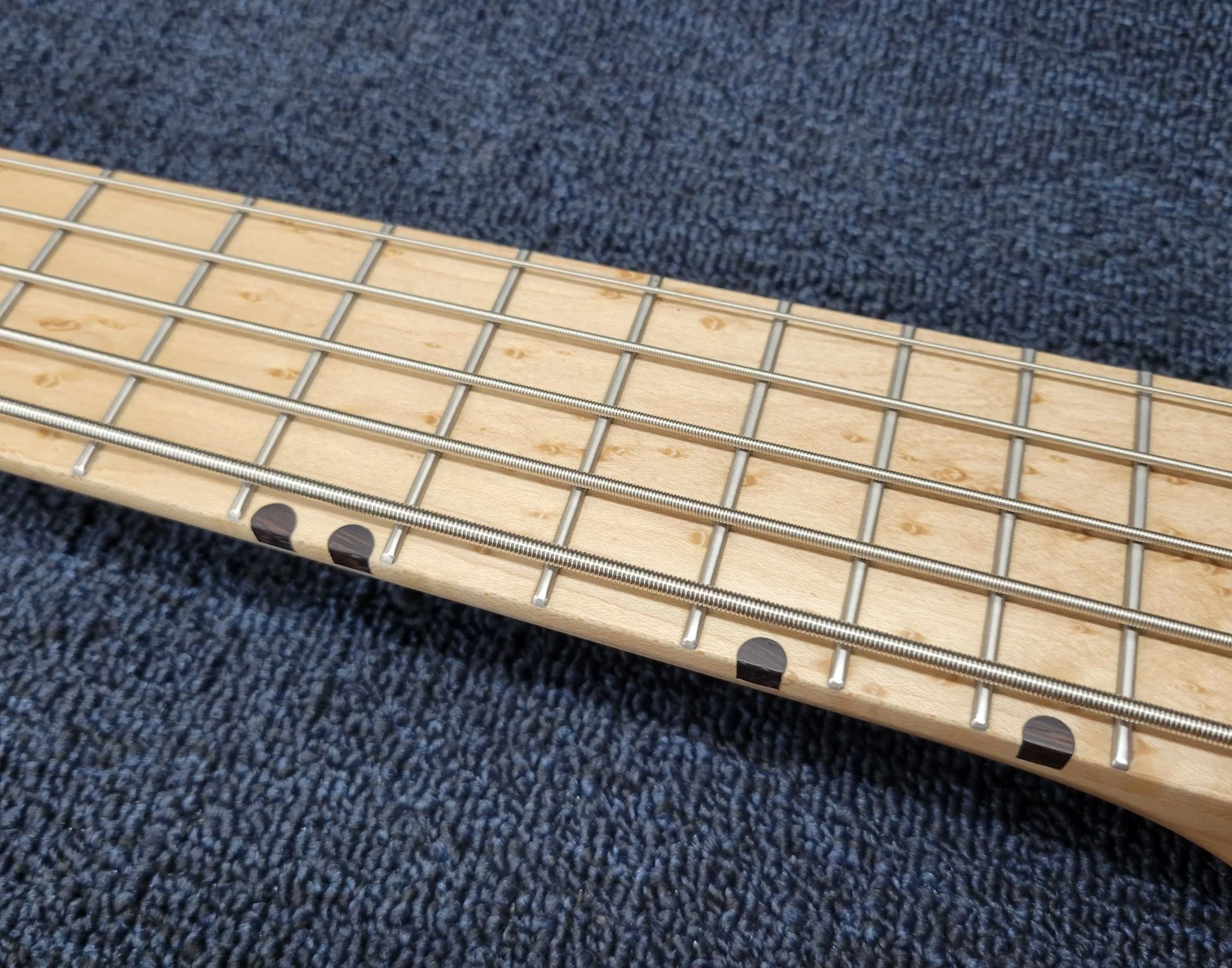 24 stainless steel Jescar pocketed frets with contrasting edge dots. Birdseye Maple fingerboard shown. Wenge Also available.