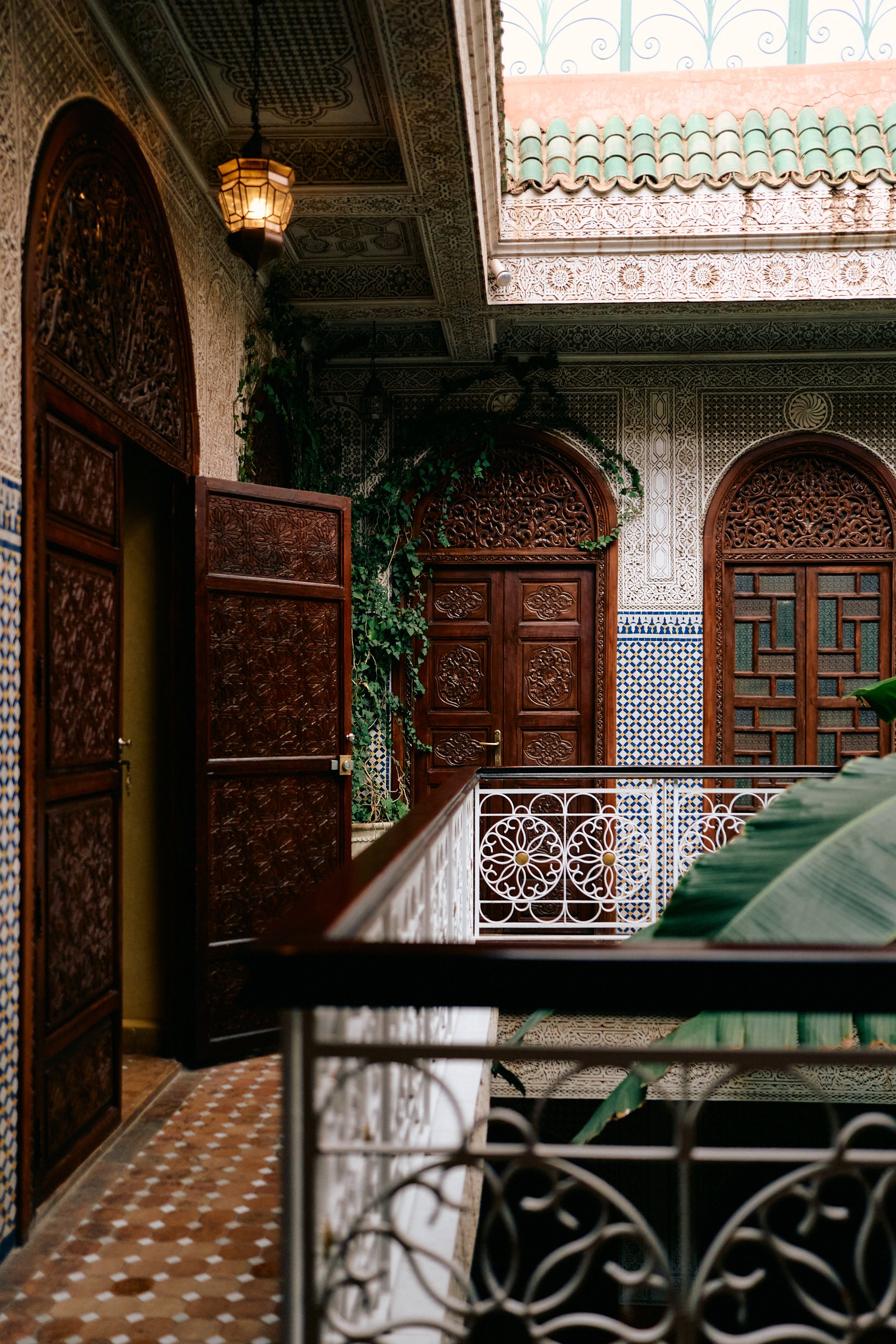 Zicht op de, met palmbomen versierde, binnenplaats van Riad Jardin in Marrakech. 