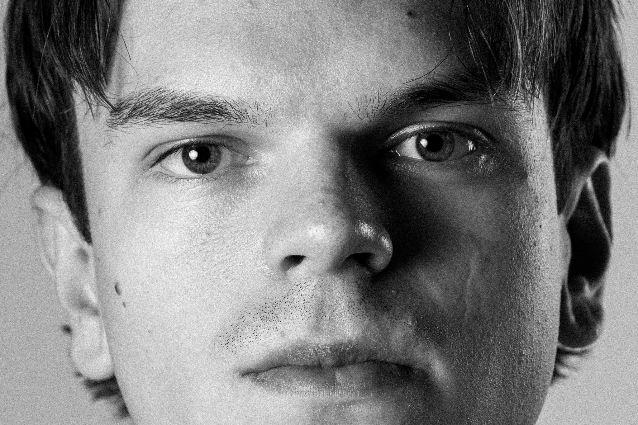 Nahaufnahme eines jungen Mannes, Studioporträt in Schwarzweiß