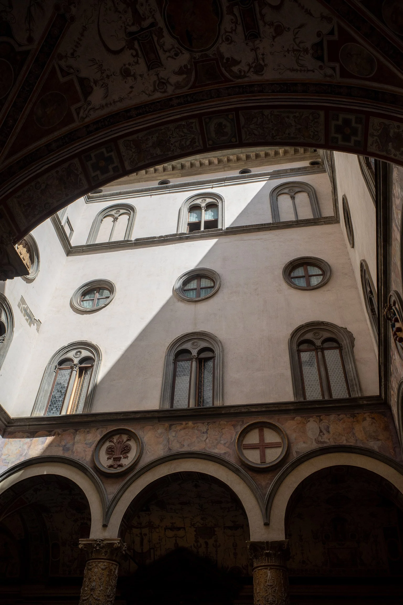 Innenhof eines historischen Gebäudes mit dekorativen Bögen und verzierten Wänden im Renaissance-Stil.