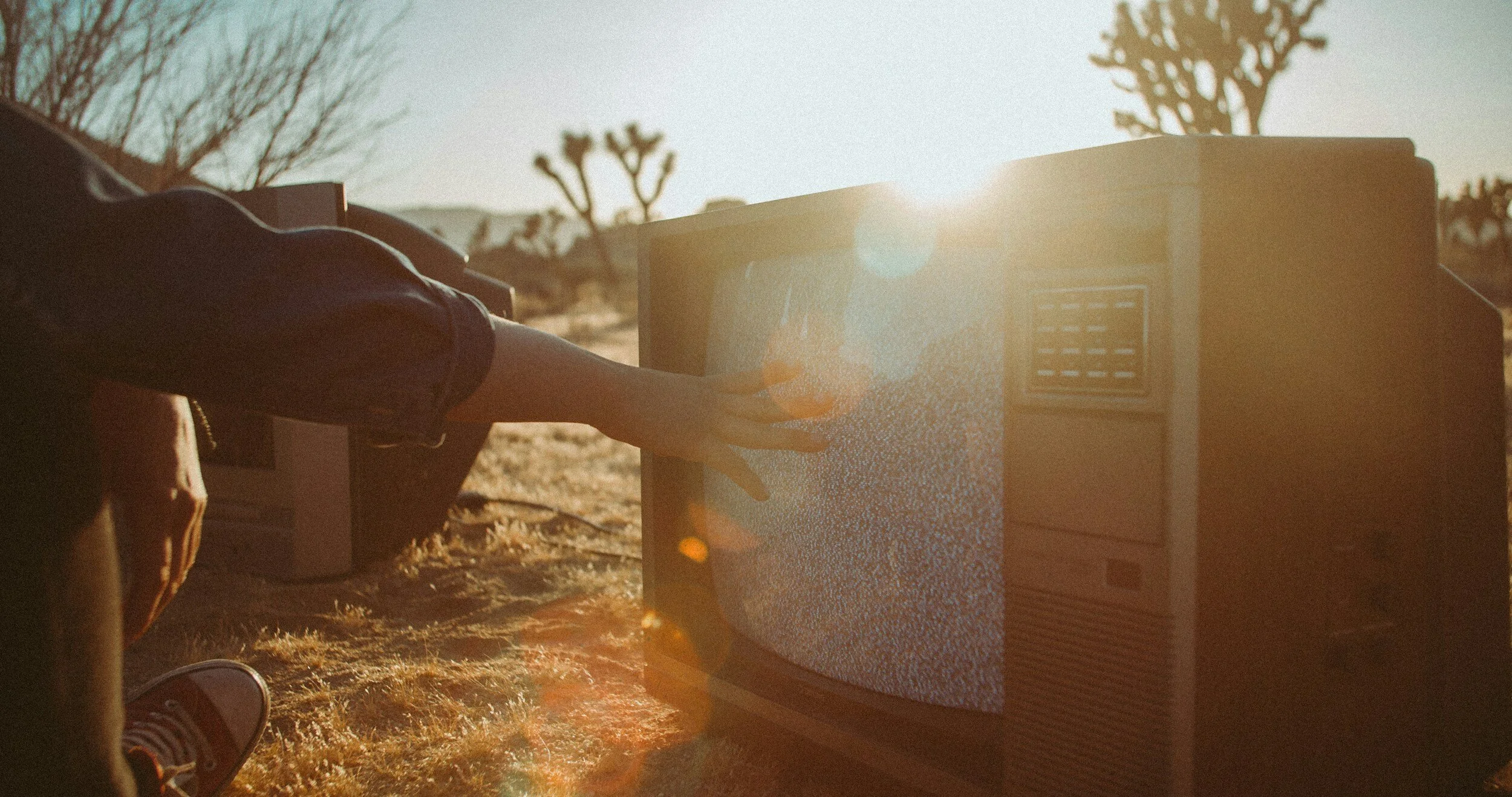 Person touching static on TV screen outdoors in nature