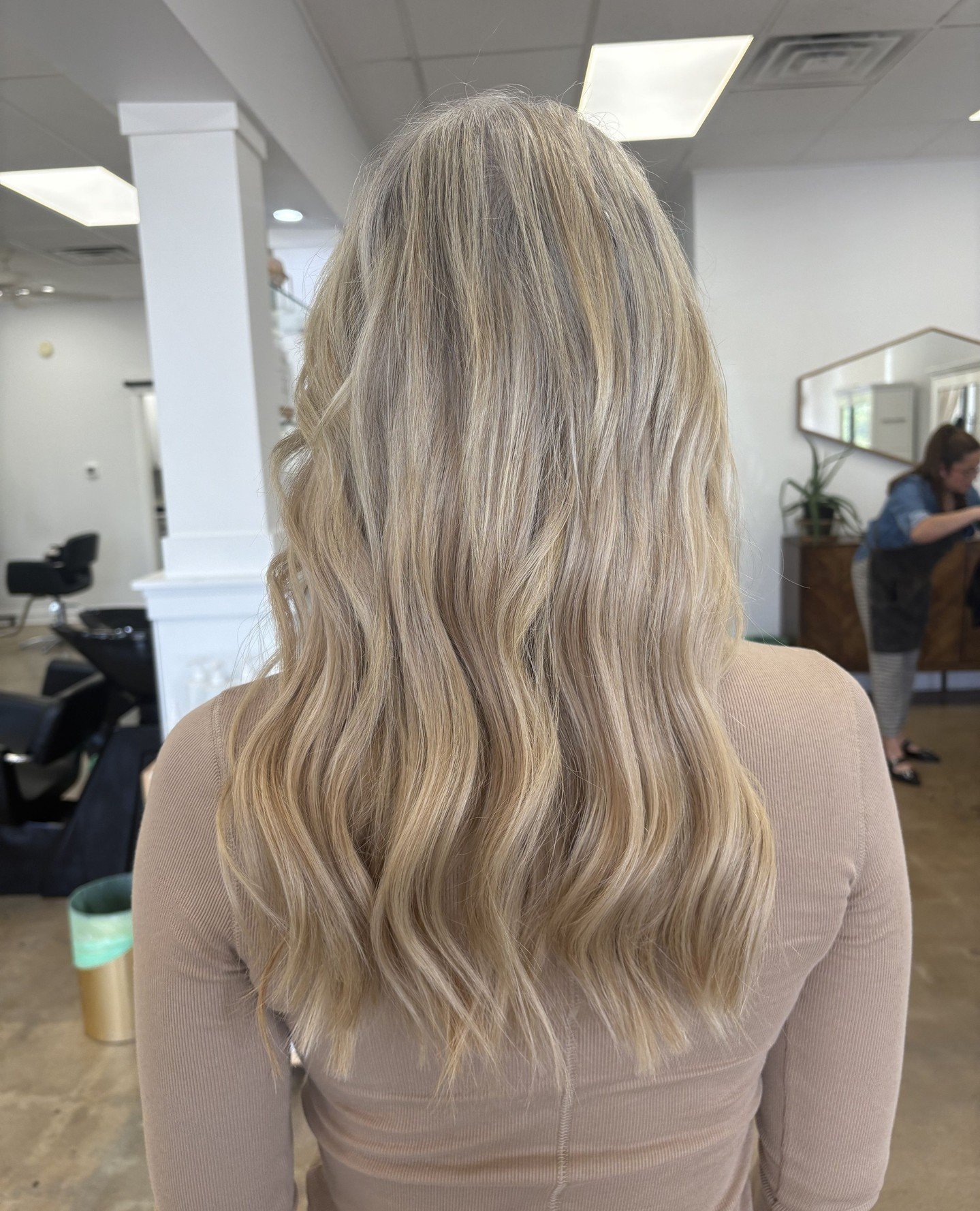 Blonde highlights with seamless hand tied extensions. This look has brightness, movement, and a natural blend that feels effortless. We used organic based color to create her tone, then added extensions for fullness that looks and feels like her own 