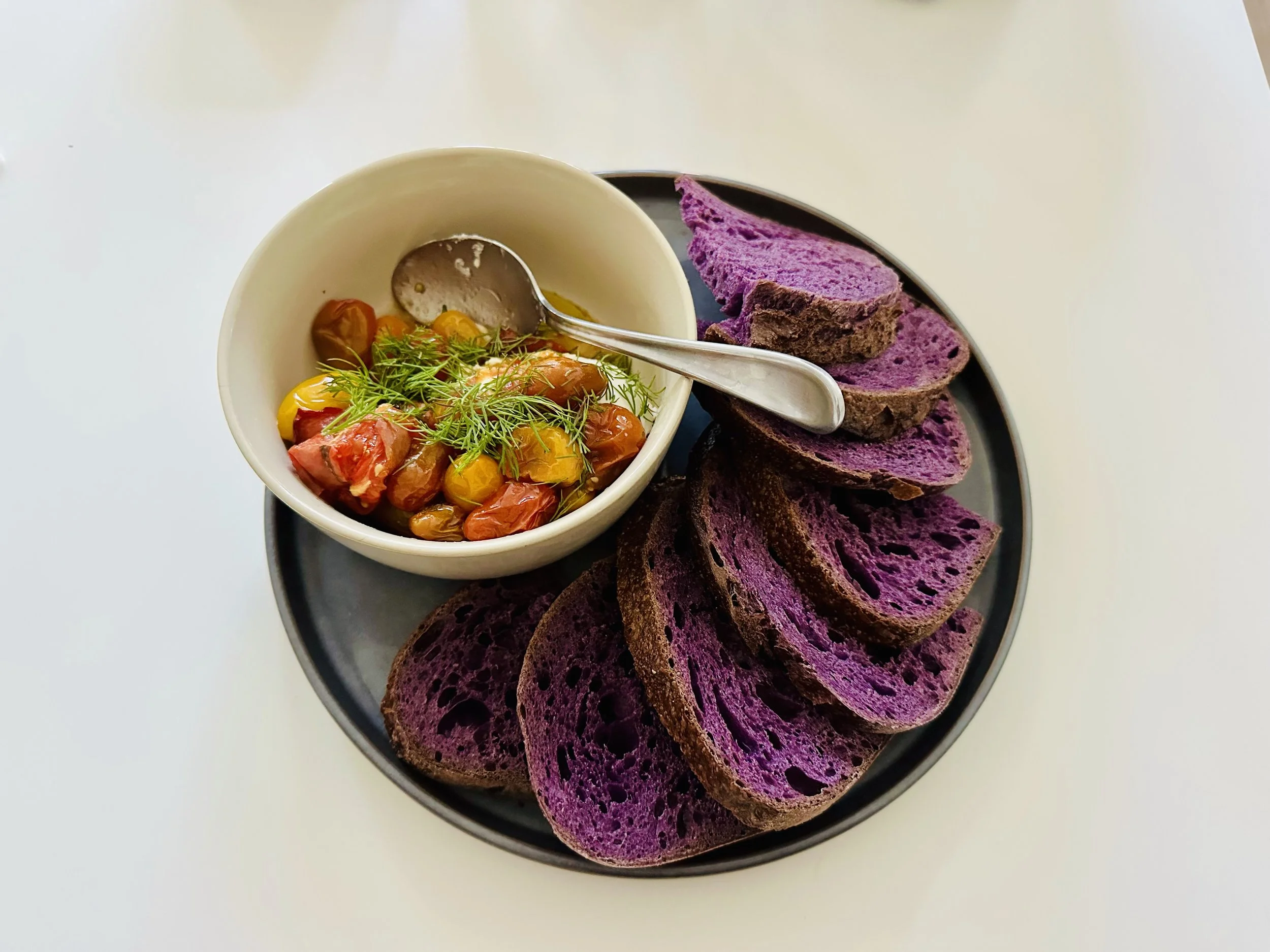 Steve's roasted tomatoes with whipped feta and dill, toasted ube sourdough from Rize Up Bakery