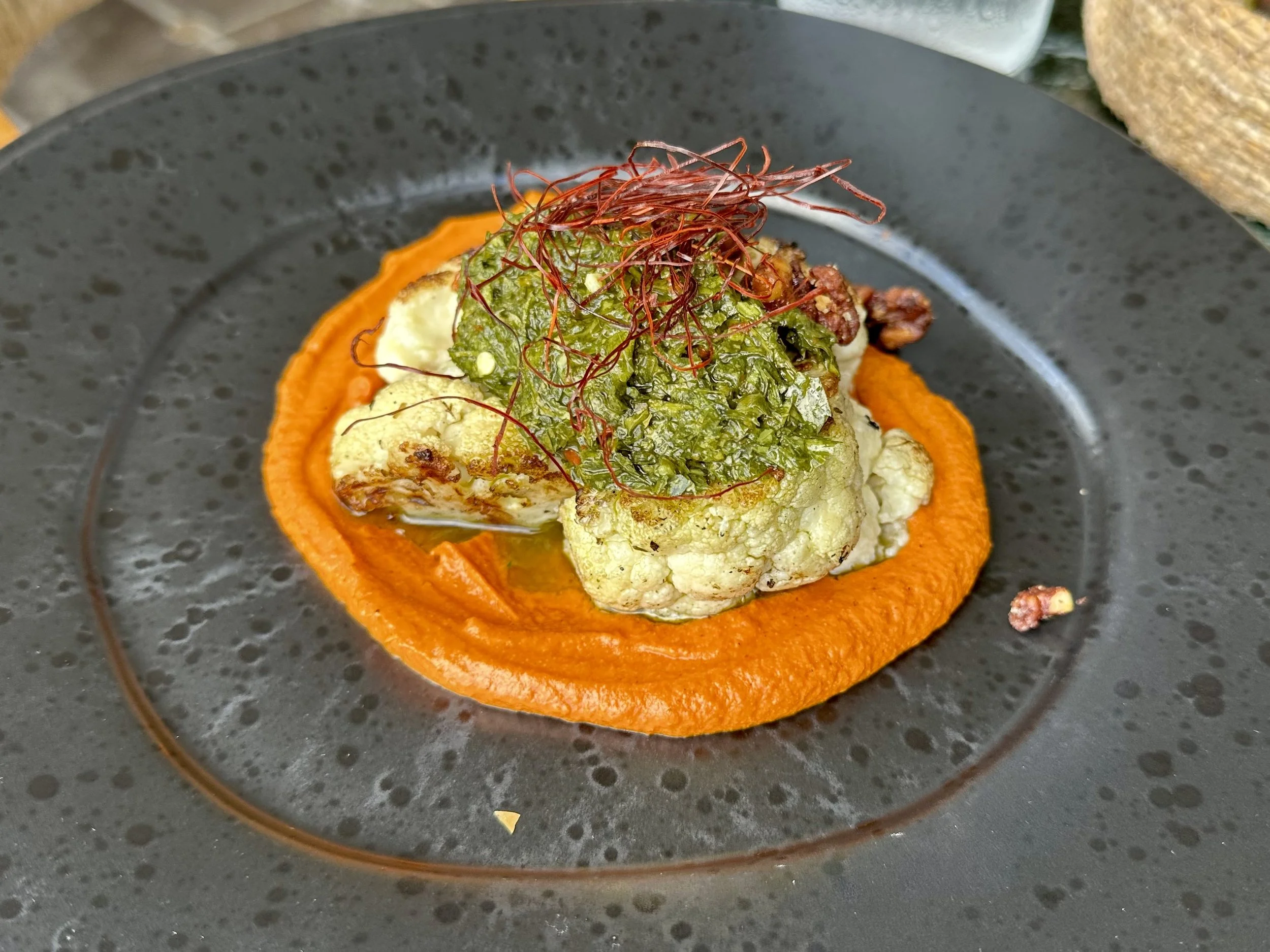 Grilled cauliflower with chimichurri sauce, caramelized walnut, pepper cream and chili strings