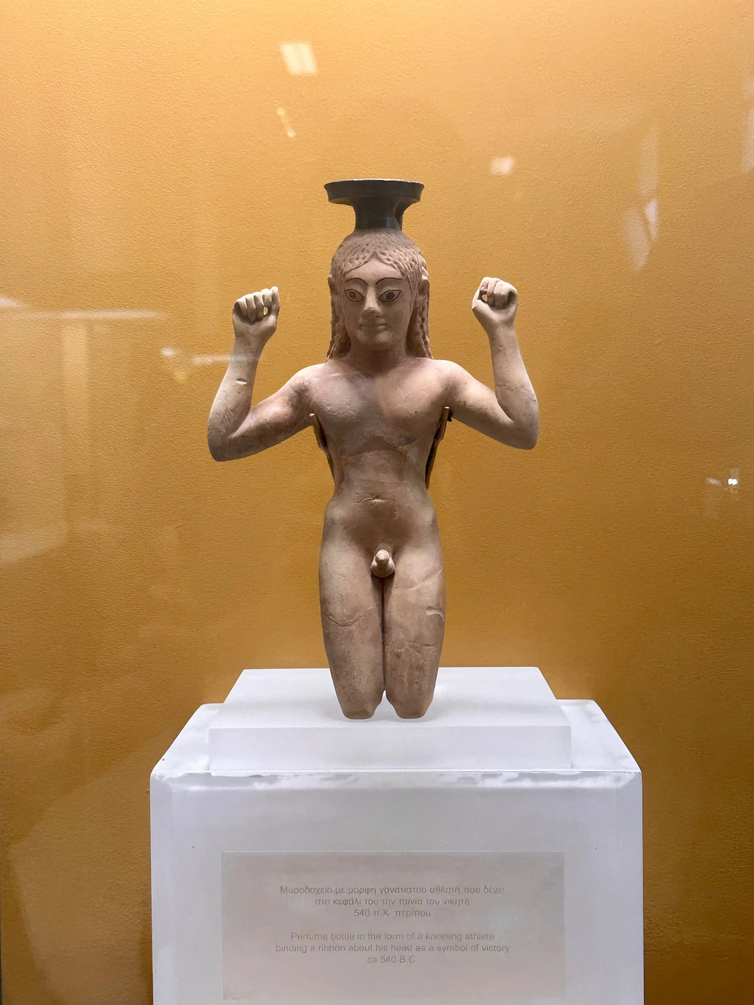 Perfume bottle in the form of a kneeling athlete binding a ribbon around his head as a symbol of victory