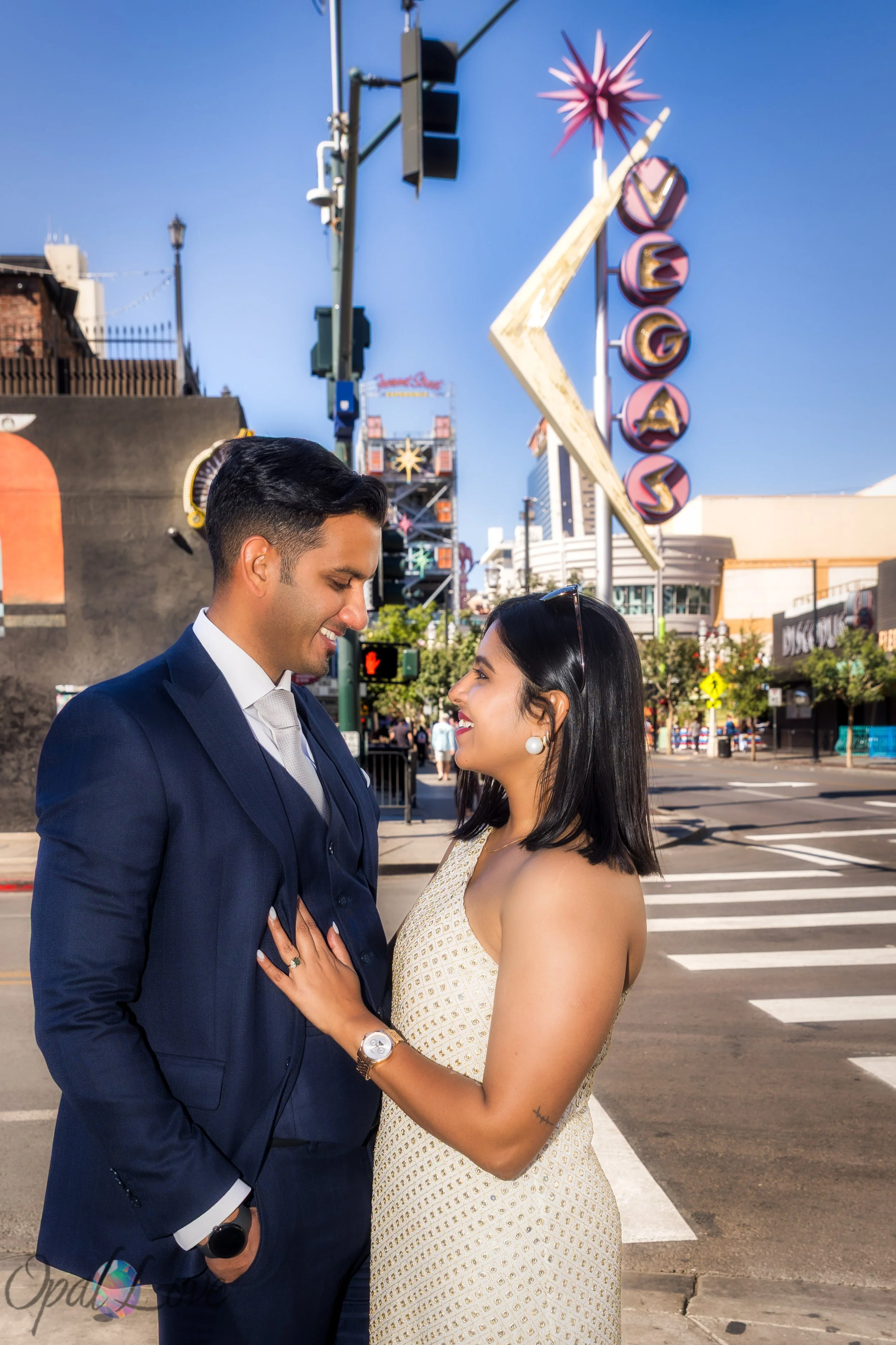 Couple standing beneath the retro Vegas mural sign downtown.