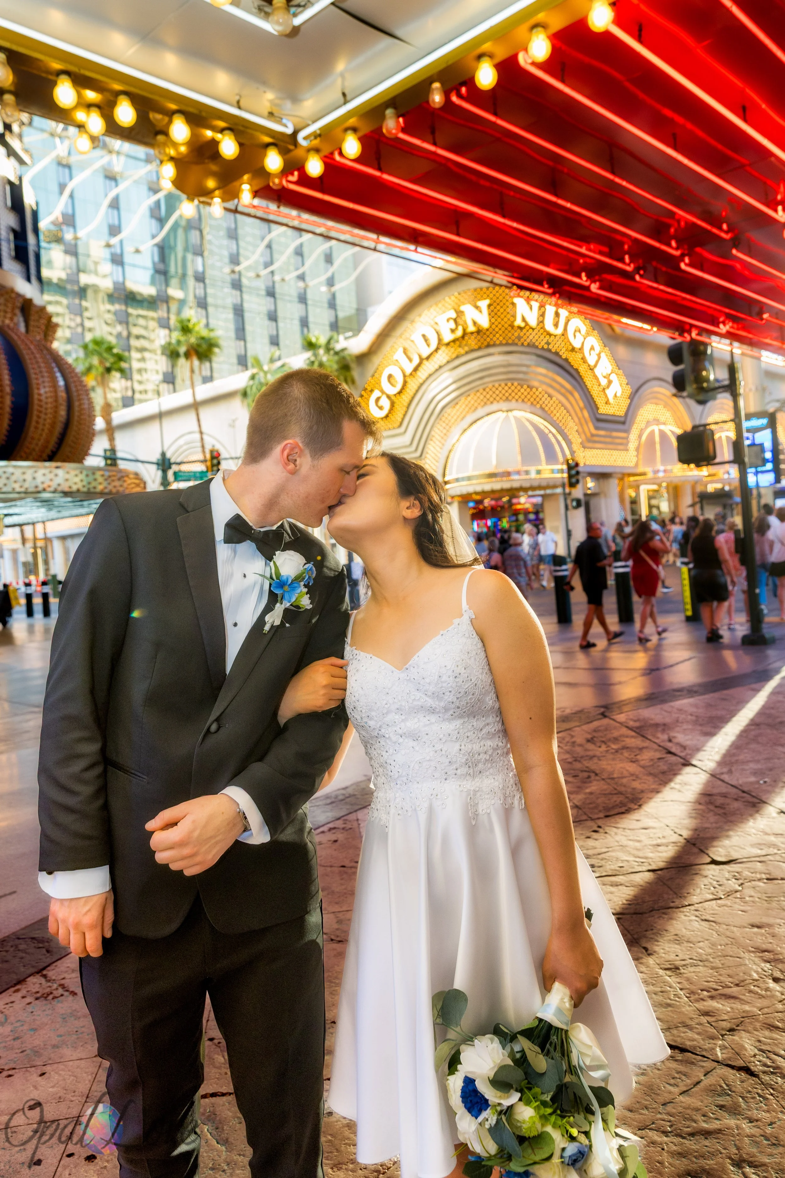 Bride and groom kissing beneath the neon lights on Fremont Street in downtown Las Vegas.