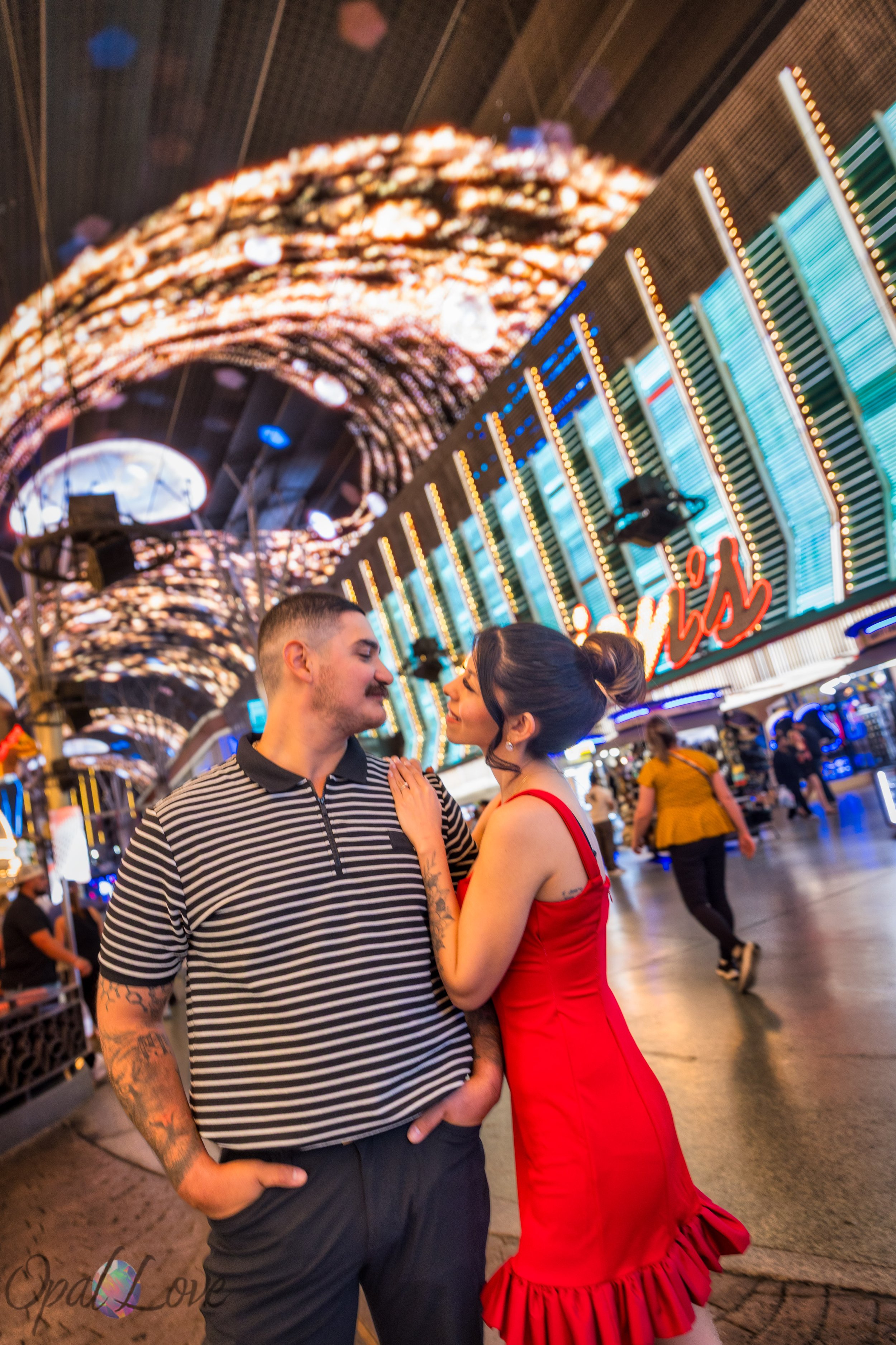 Couple sharing a moment with Fremont Street canopy glowing above them
