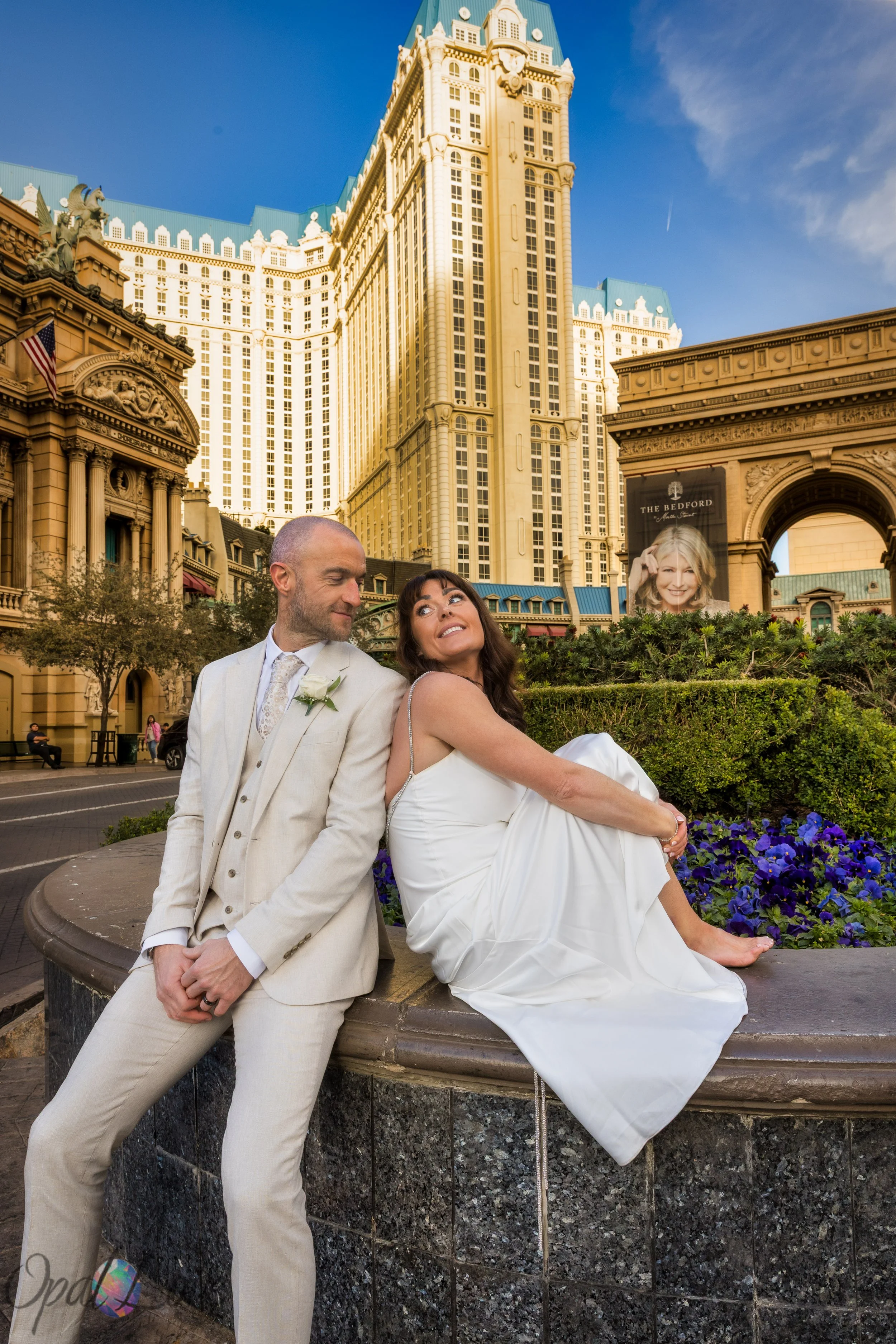 Couple sitting together in front of Paris Hotel during their Las Vegas wedding photo tour.