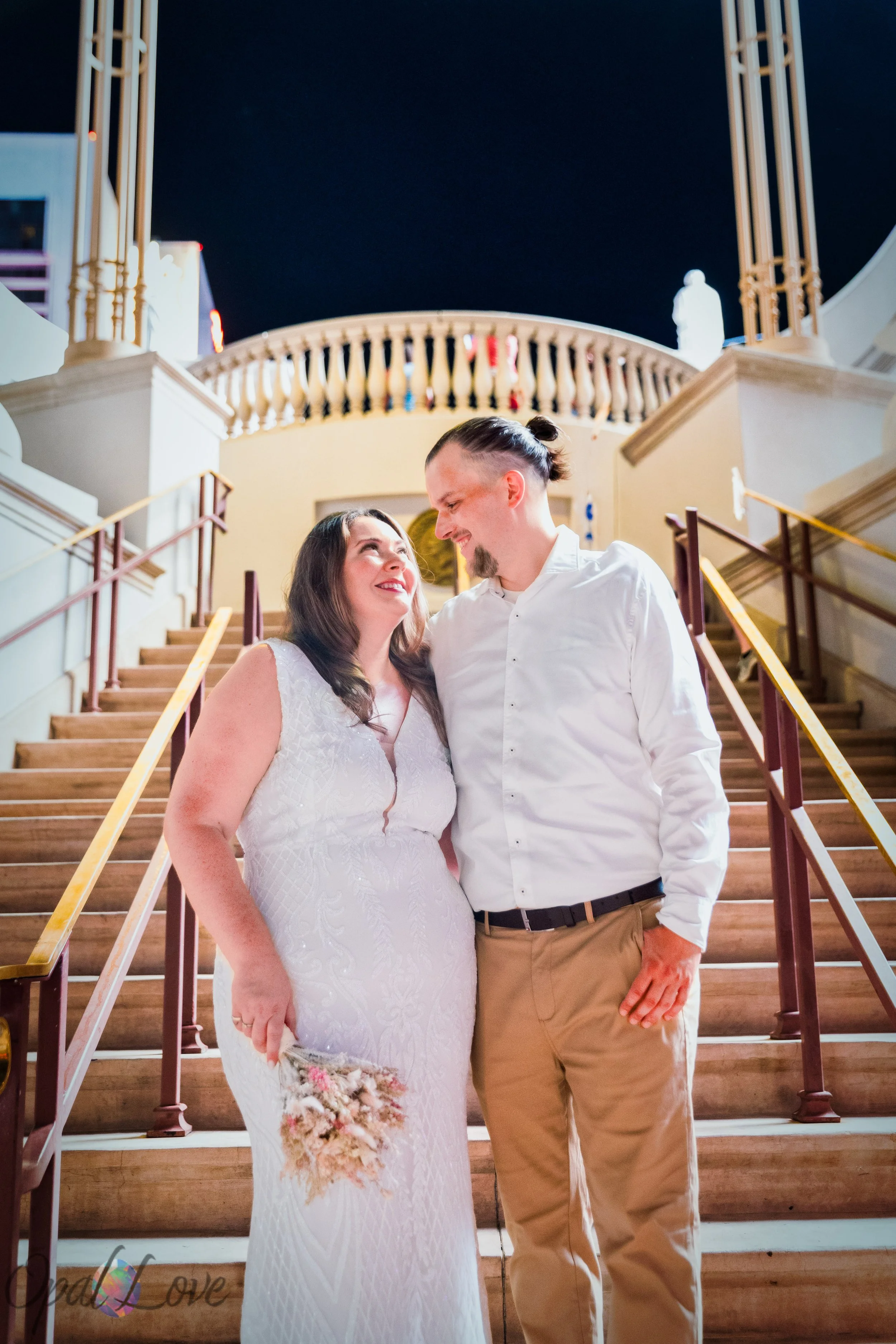 Dustin and Jacqueline posing together on the illuminated stairs at Caesars Palace during their Vegas Strip photo session.