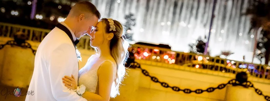 Couple sharing a playful moment in front of the Bellagio fountains in Las Vegas.