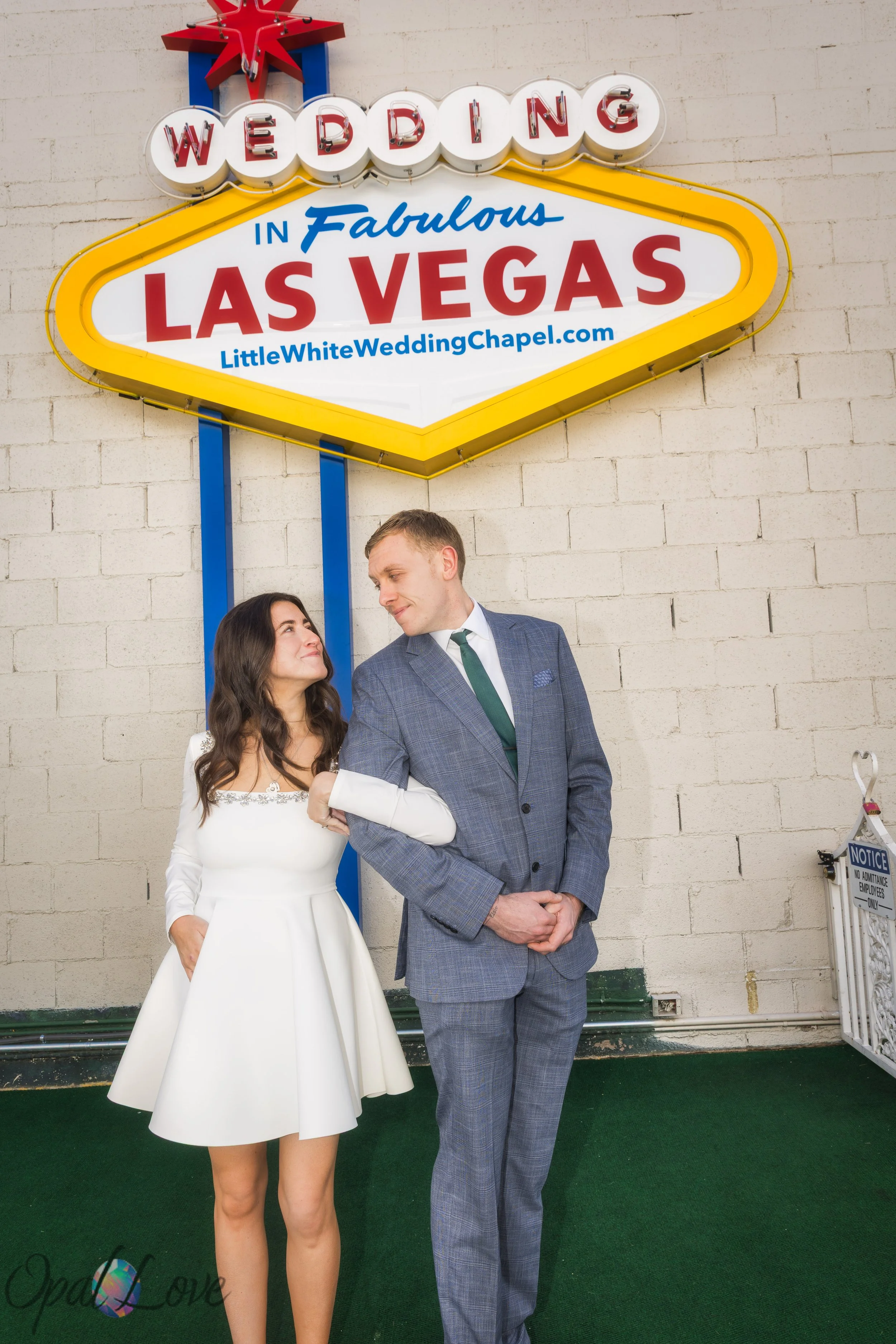 Bride and groom standing under the Welcome to Fabulous Las Vegas sign at A Little White Wedding Chapel during their Las Vegas elopement.