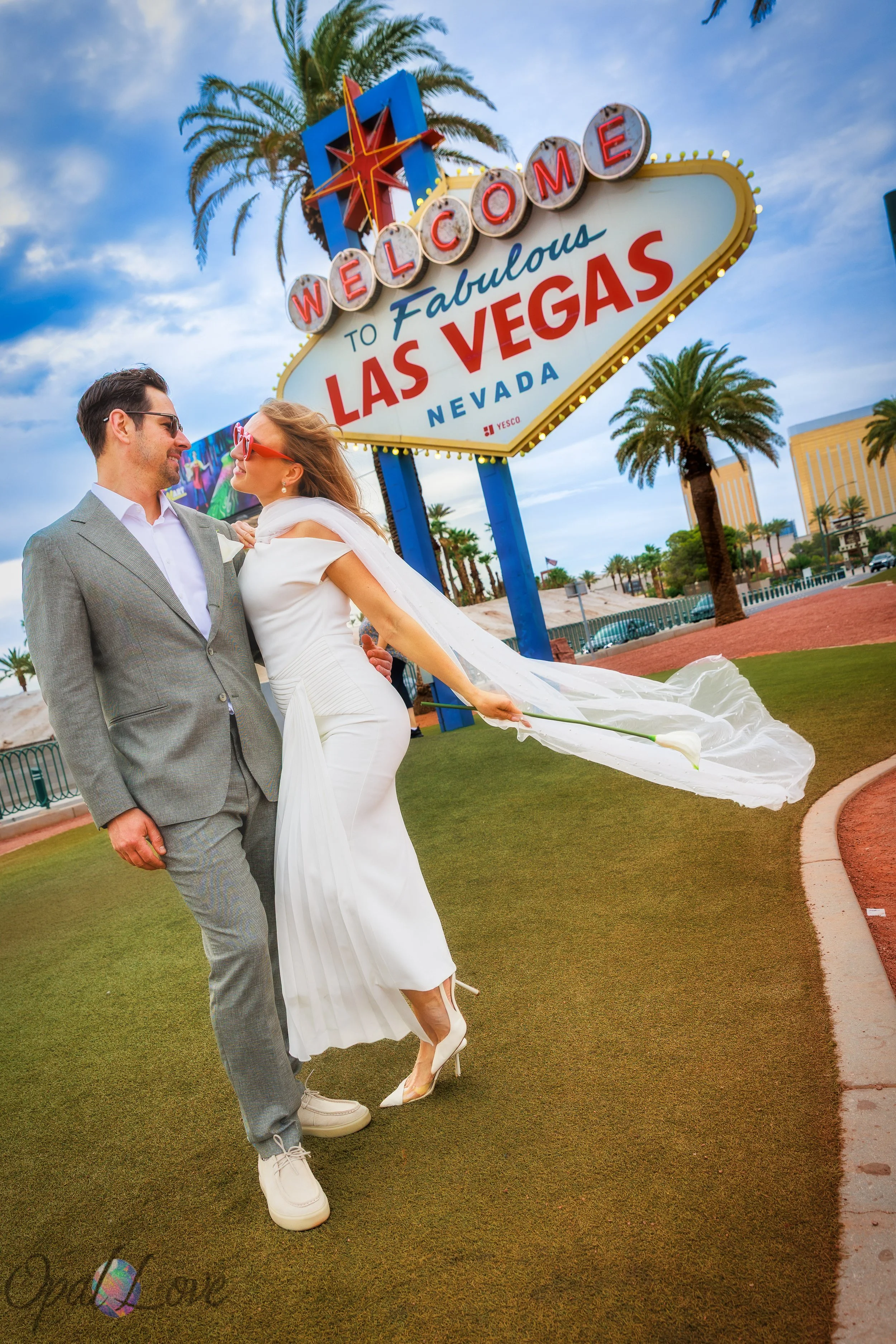 Couple posing in front of the welcome to Las Vegas sign