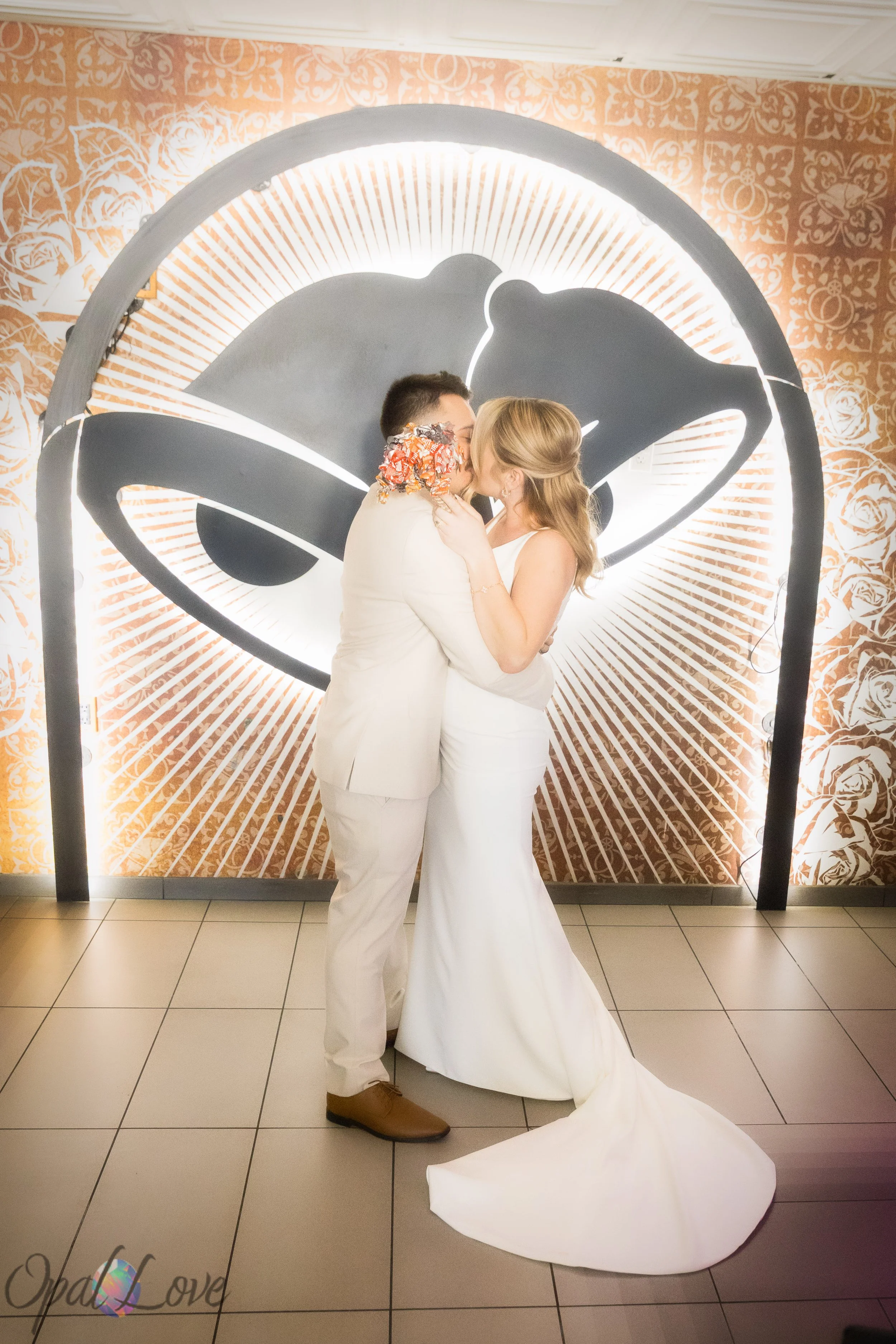 Bride and groom kissing under illuminated wall design inside Taco Bell Cantina Las Vegas wedding venue.