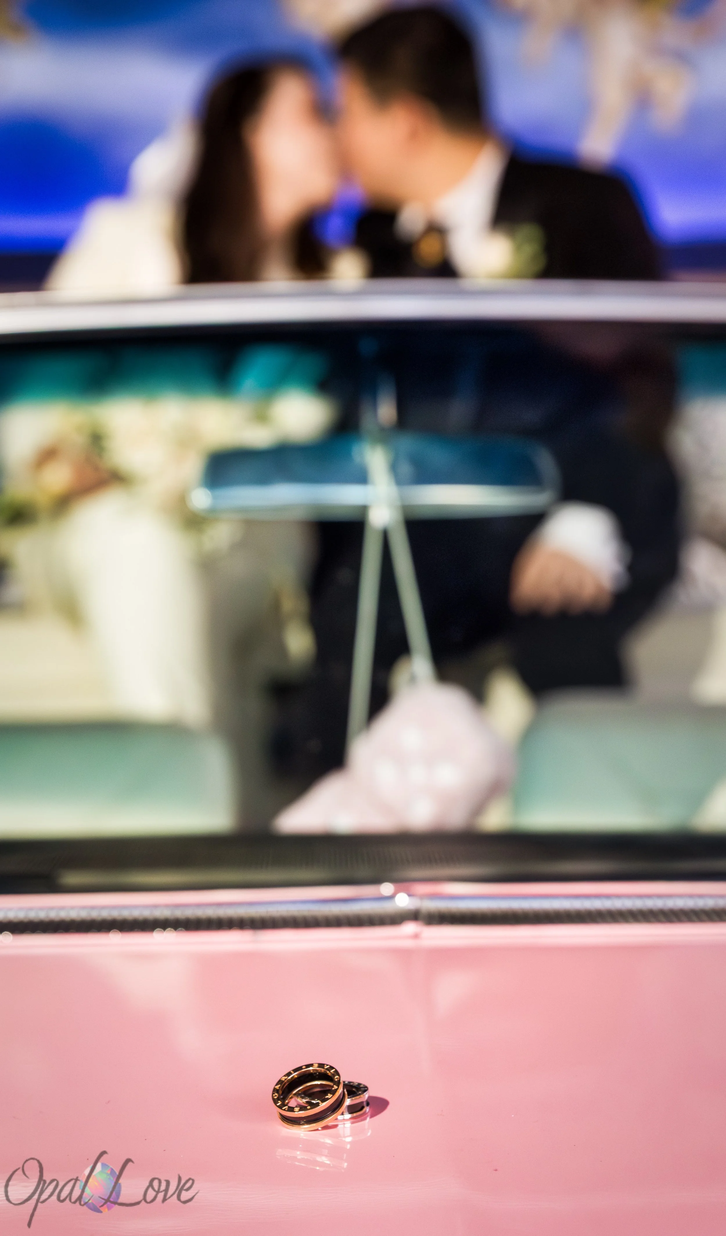 Wedding rings on Pink Cadillac with couple blurred in background