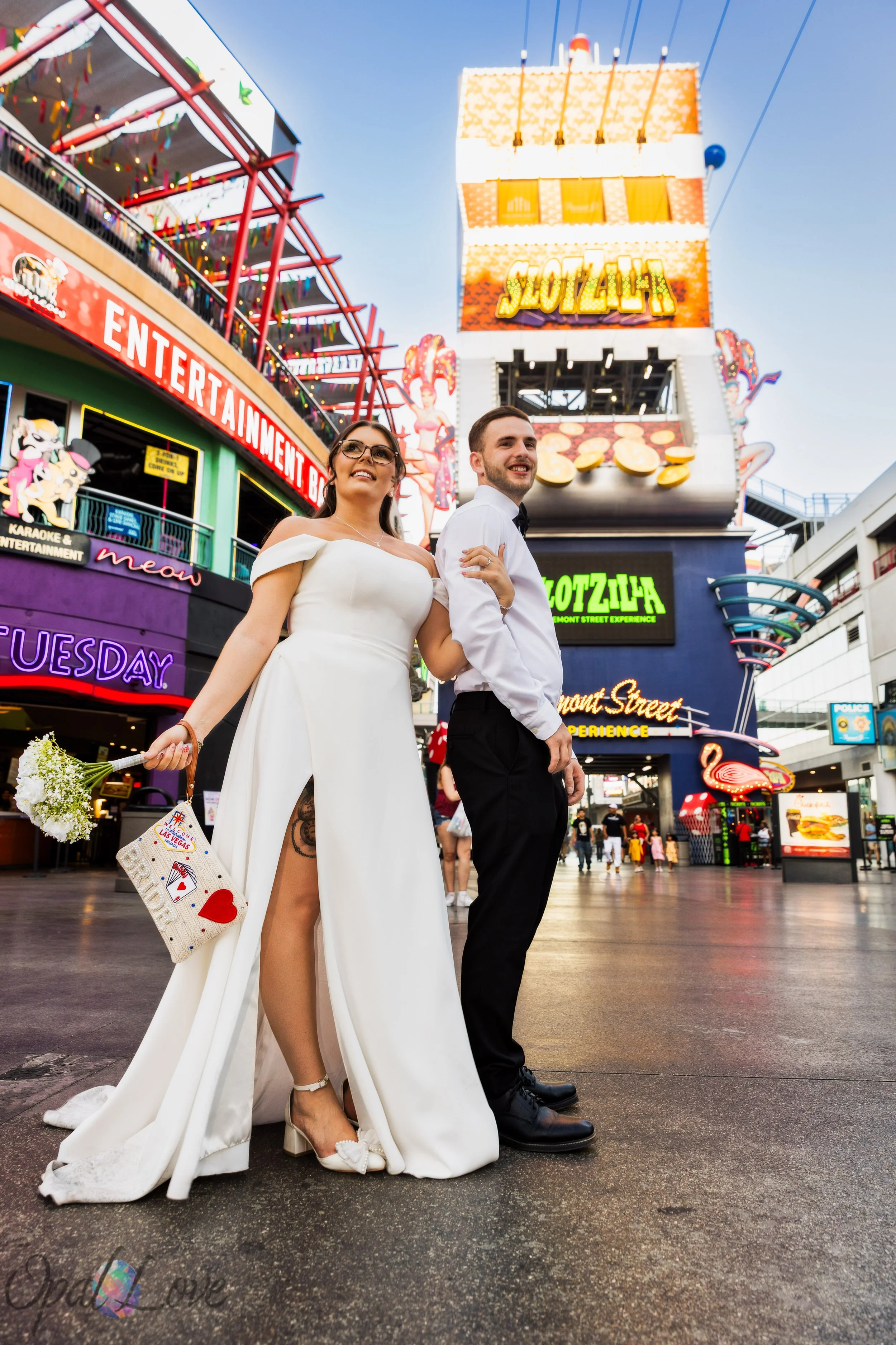 Newly married couple posing at Fremont Street Experience surrounded by neon lights in Downtown Las Vegas.