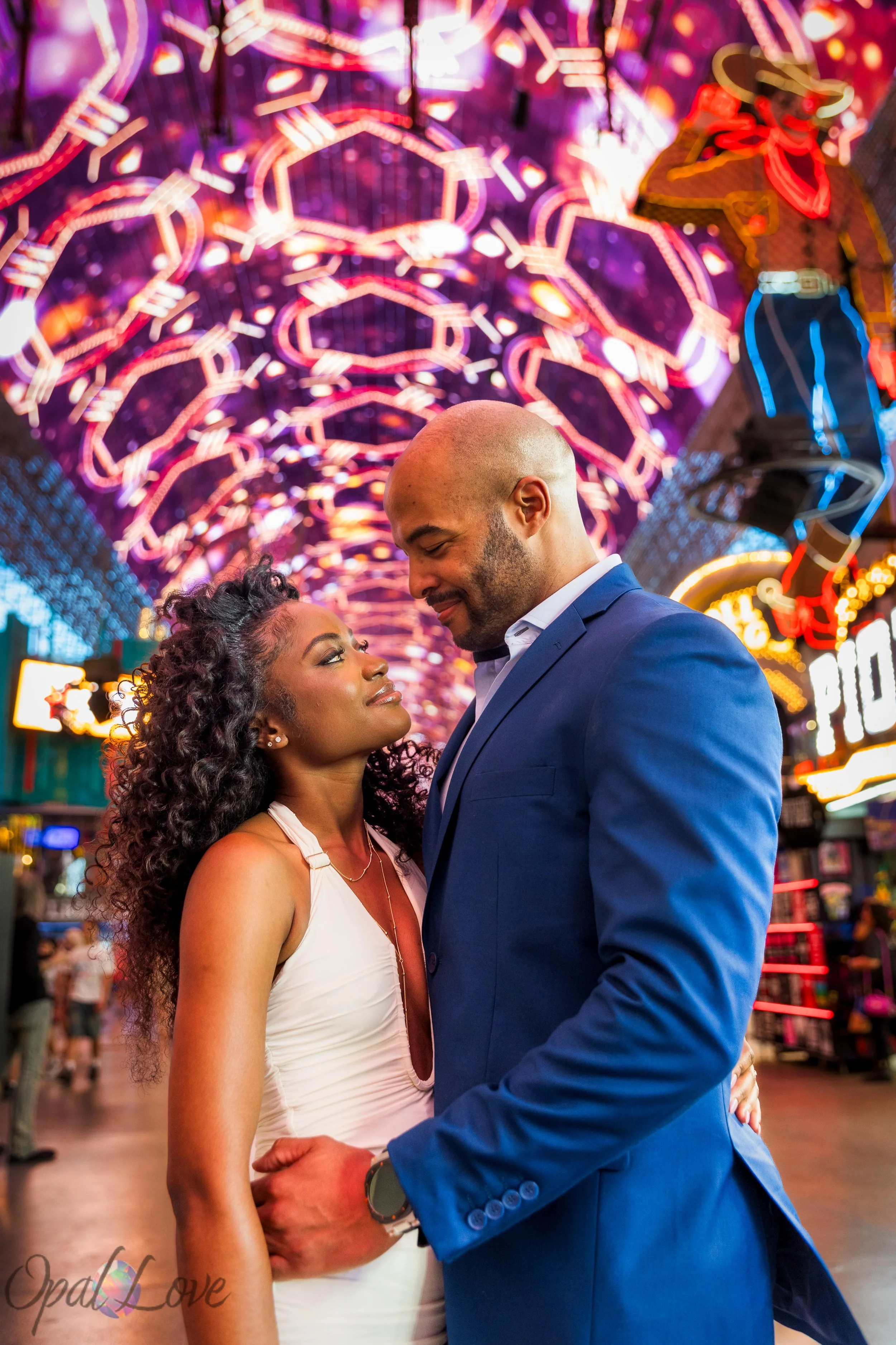 Couple standing together under the colorful Viva Vision canopy on Fremont Street in downtown Las Vegas.