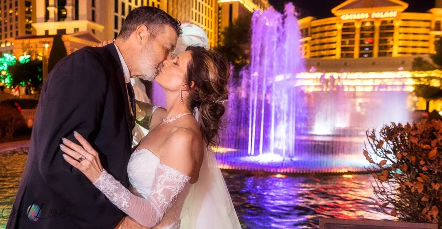 Newlywed couple kissing in front of the fountains at Caesars Palace in Las Vegas.
