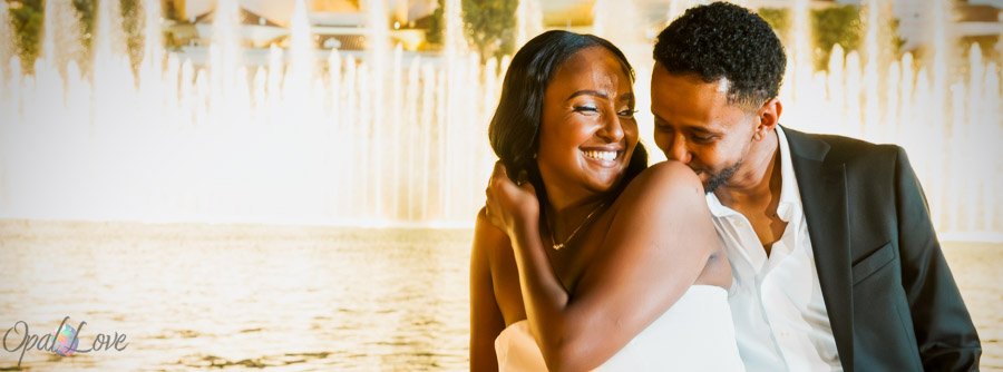 Couple sharing a playful moment in front of the Bellagio fountains in Las Vegas.